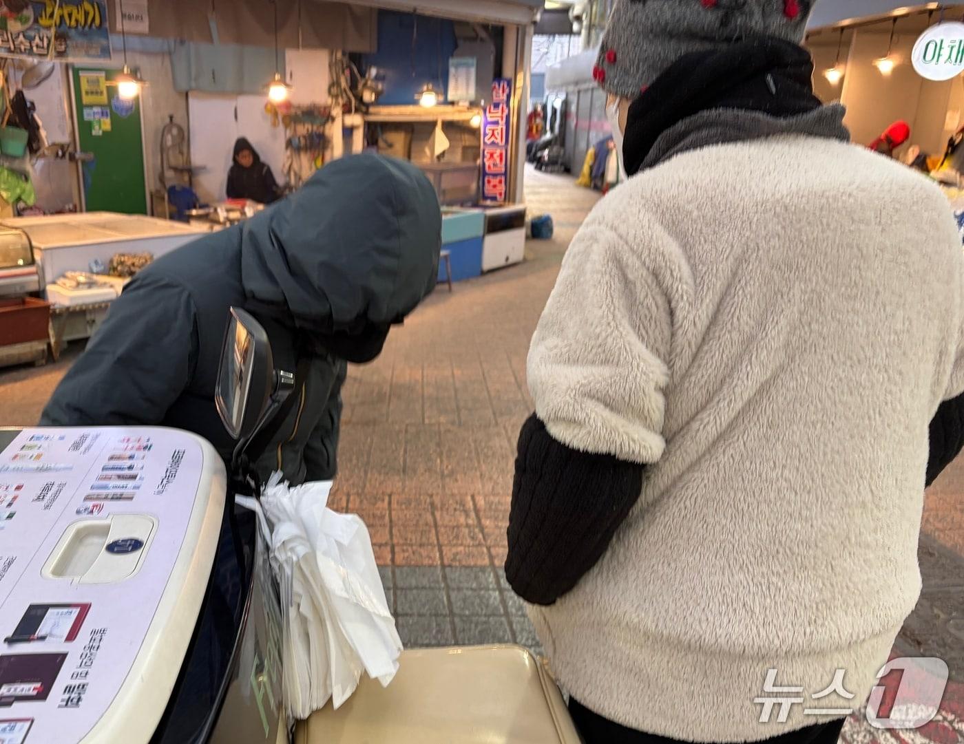 본문 이미지 - 3일 오전 8시 10분쯤 서울 영등포구 영등포전통시장에서 유제품 배달원과 시장 상인이 갑자기 추워진 날씨에 대해 이야기하고 있다. 2025.12.3/ 뉴스1 김종훈 기자