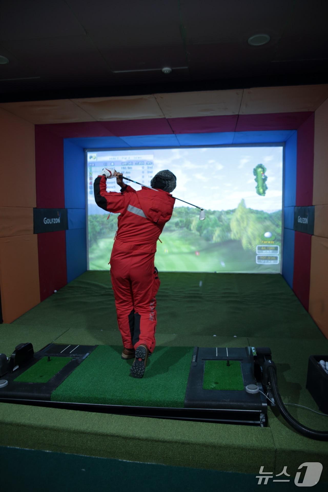 본문 이미지 - 남극 세종과학기지에 설치된 골프존 시뮬레이터에서 한 연구대원이 스크린골프 라운드를 하고 있다. &#40;골프존 제공&#41;
