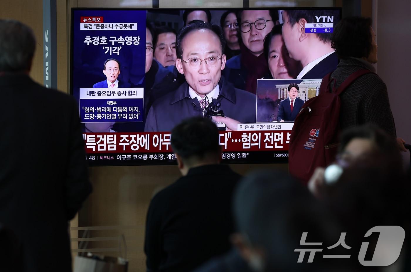 12·3 비상계엄 1년을 맞은 3일 오전 서울 중구 서울역 대합실에서 시민들이 비상계엄 해제 표결 참여를 방해한 혐의를 받는 추경호 국민의힘 의원의 구속영장 기각 관련 뉴스를 지켜보고 있다. 2025.12.3/뉴스1 ⓒ News1 오대일 기자