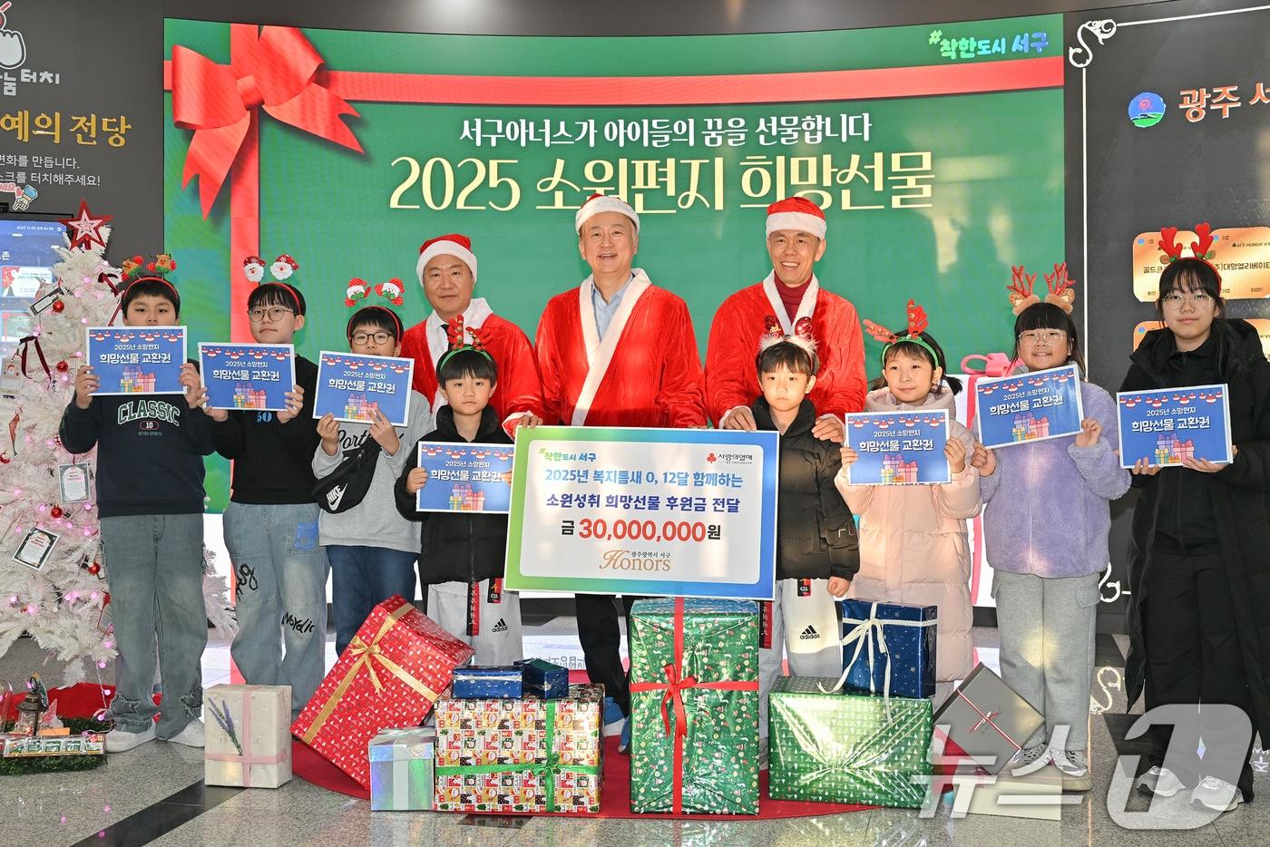 김이강 광주 서구청장이 3일 서구아너스로부터 받은 '소원성취 희망선물'을 지역 아동‧청소년에게 전달하고 사진 촬영하고 있다.(광주 서구 제공. 재판매 및 DB금지) 2025.12.3/뉴스1 