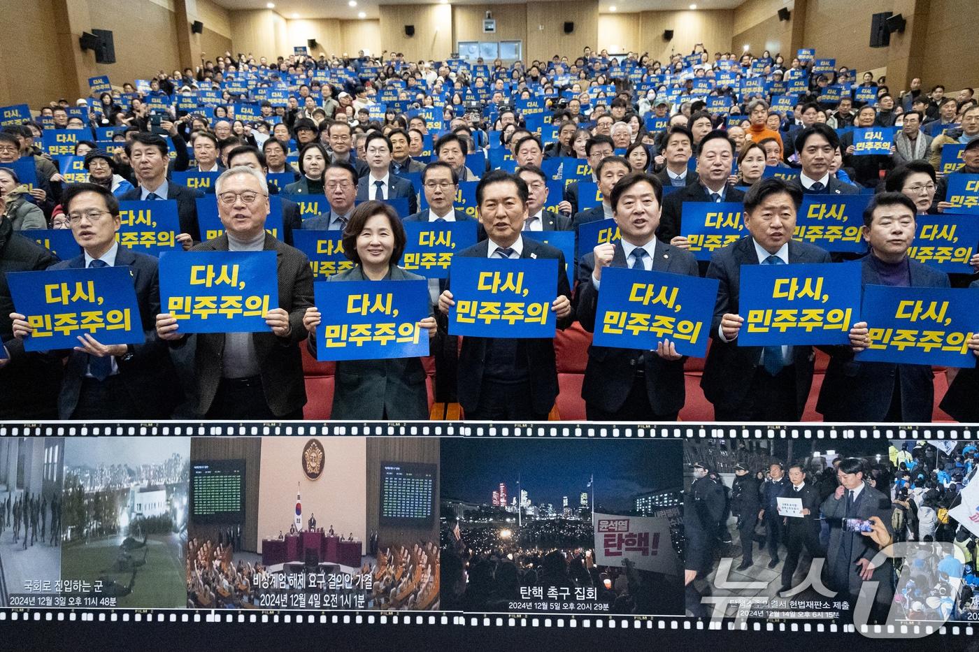 정청래 더불어민주당 대표를 비롯한 참석자들이 3일 서울 여의도 국회 의원회관에서 열린 12.3 내란 저지 1년 특별좌담회 &#39;행동하는 K-민주주의&#39;에서 &#39;다시, 민주주의&#39; 손팻말을 들고 구호를 외치고 있다. 2025.12.3/뉴스1 ⓒ News1 유승관 기자