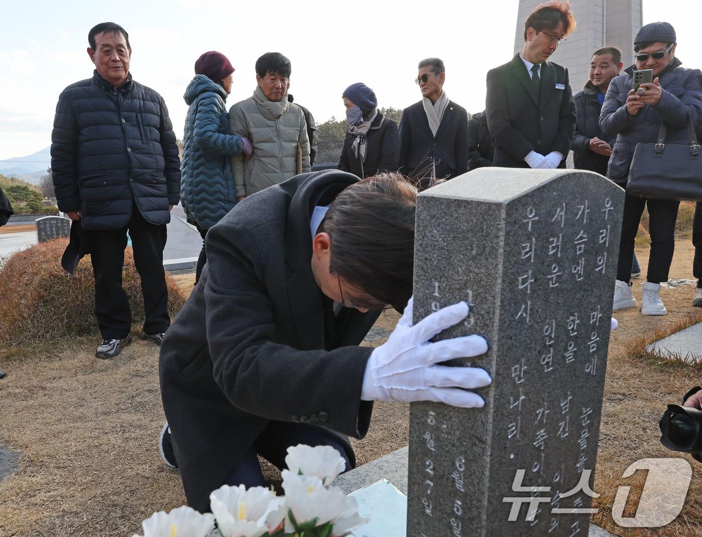 본문 이미지 - 12·3 불법 비상계엄 1년이 된 3일 조경태 국민의힘 의원이 광주 북구 운정동 국립 5·18민주묘지 문재학 열사 묘역에서 무릎 꿇은 채 기도하고 있다. 2025.12.3/뉴스1 ⓒ News1 박지현 기자