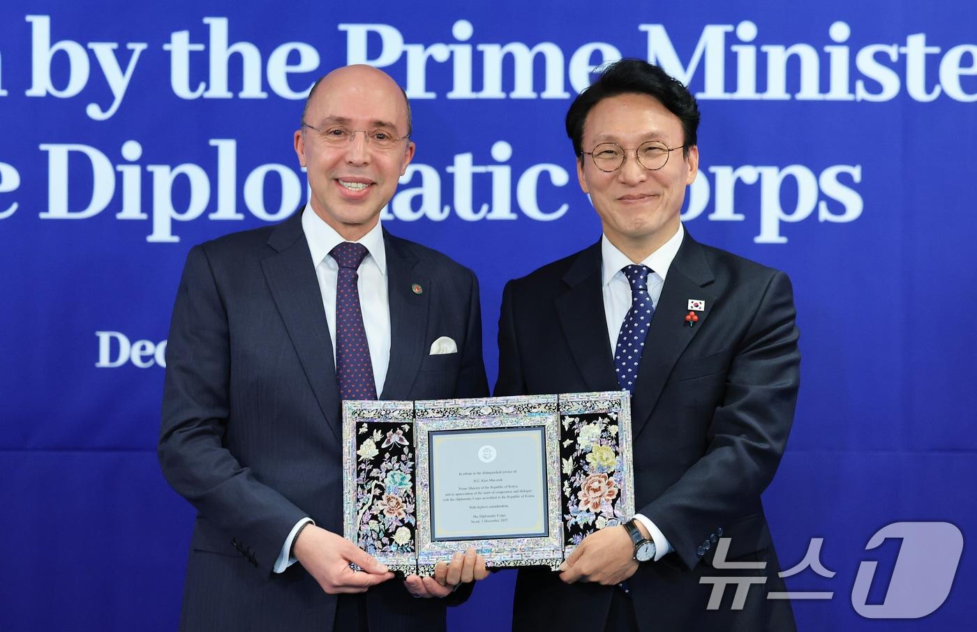 김민석 국무총리가 3일 서울 중구 소공동 롯데호텔에서 열린 국무총리 주최 주한 외교단 초청 리셉션에서 주한 외교단장인 샤픽 하샤디 주한모로코대사로부터 감사패를 받고 있다. 2025.12.3/뉴스1 ⓒ News1 임세영 기자