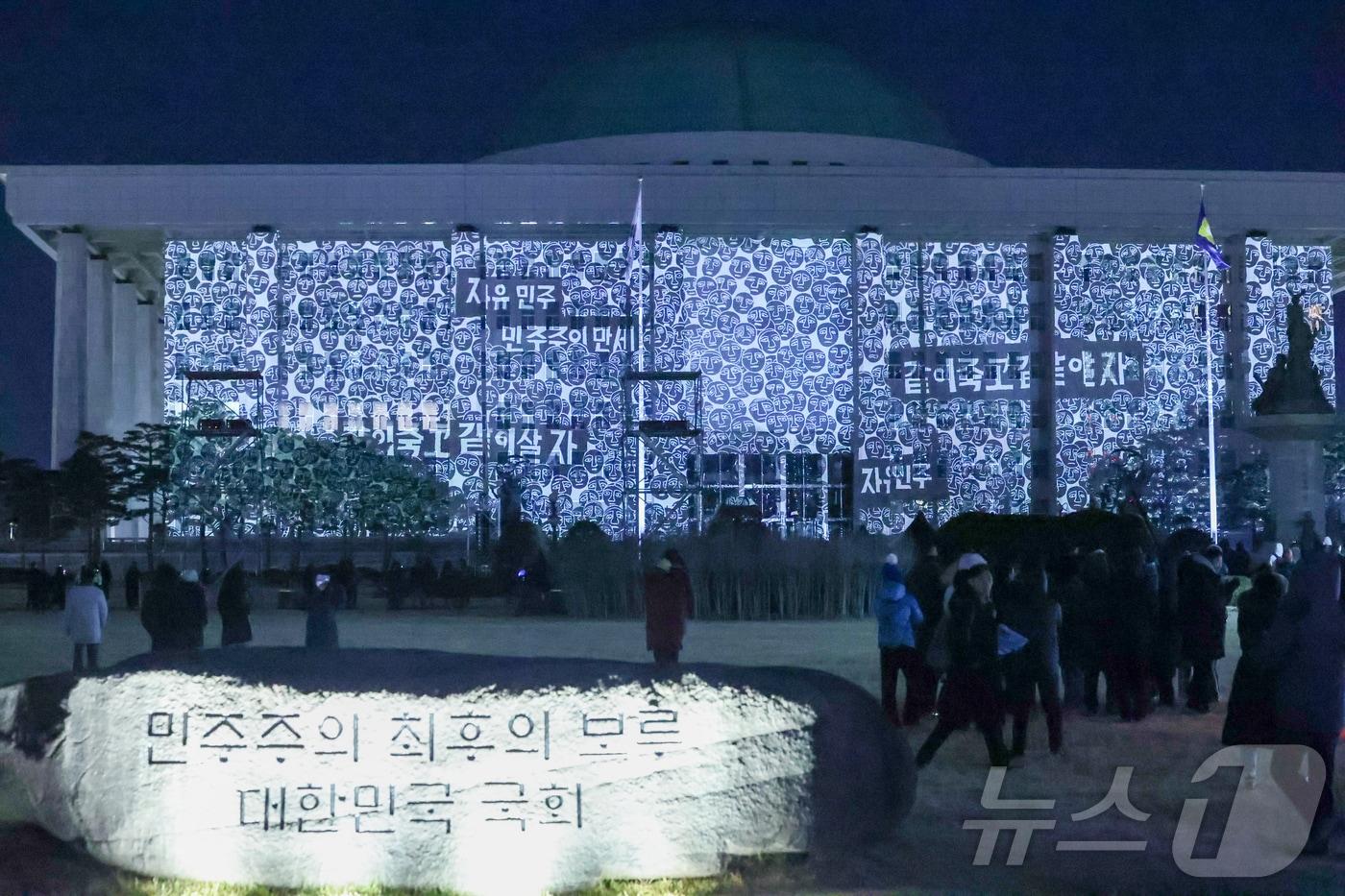본문 이미지 - 12·3 비상계엄 1년을 맞은 3일 오후 서울 영등포구 국회의사당에 계엄 해제 당시 기억을 되새기는 '미디어 파사드'가 펼쳐지고 있다. 2025.12.3 ⓒ 뉴스1 황기선 기자