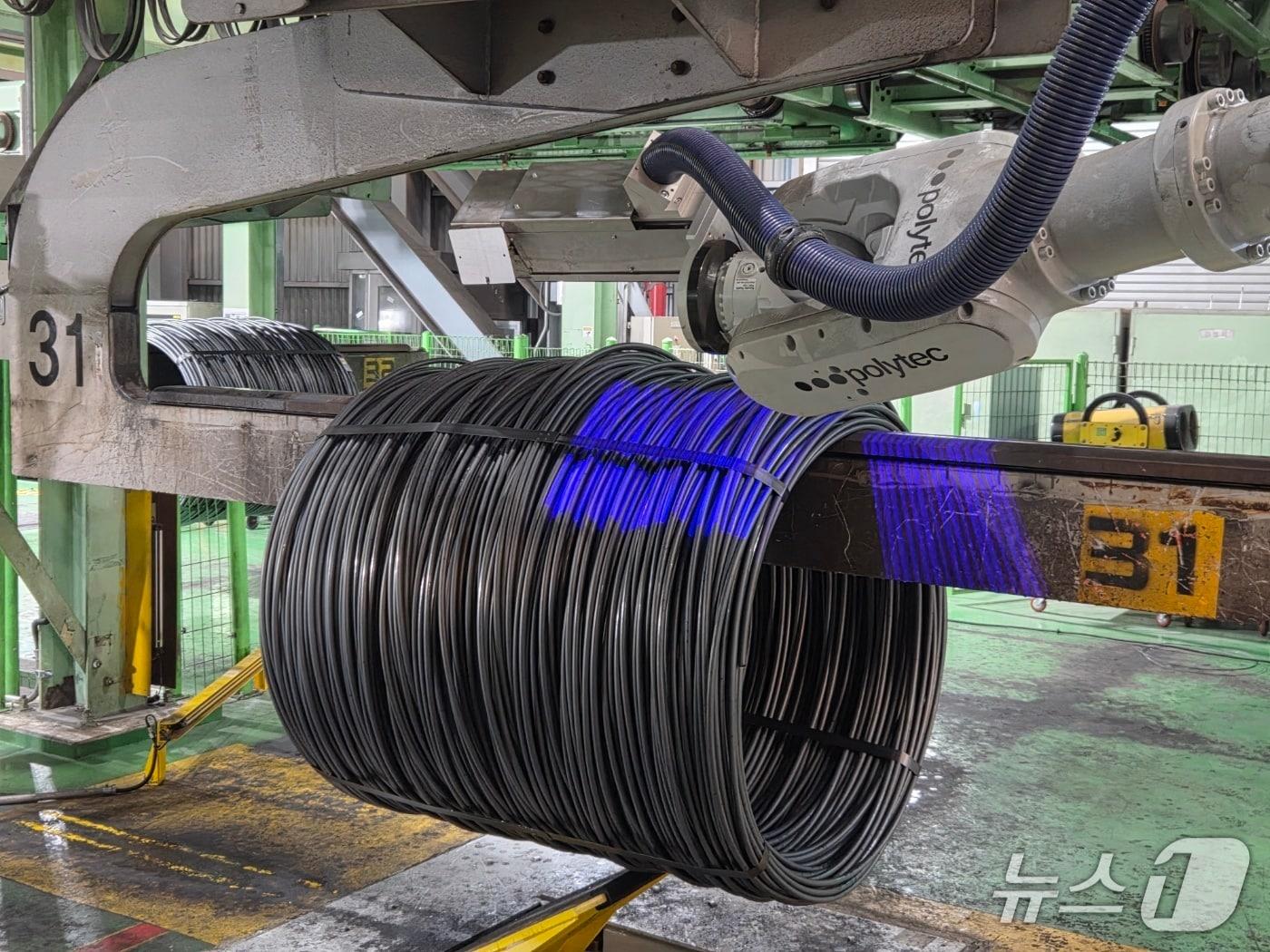 본문 이미지 - 현대제철 '선재 태깅 로봇'이 제품에 태그를 부착하는 모습.(현대제철 제공) 