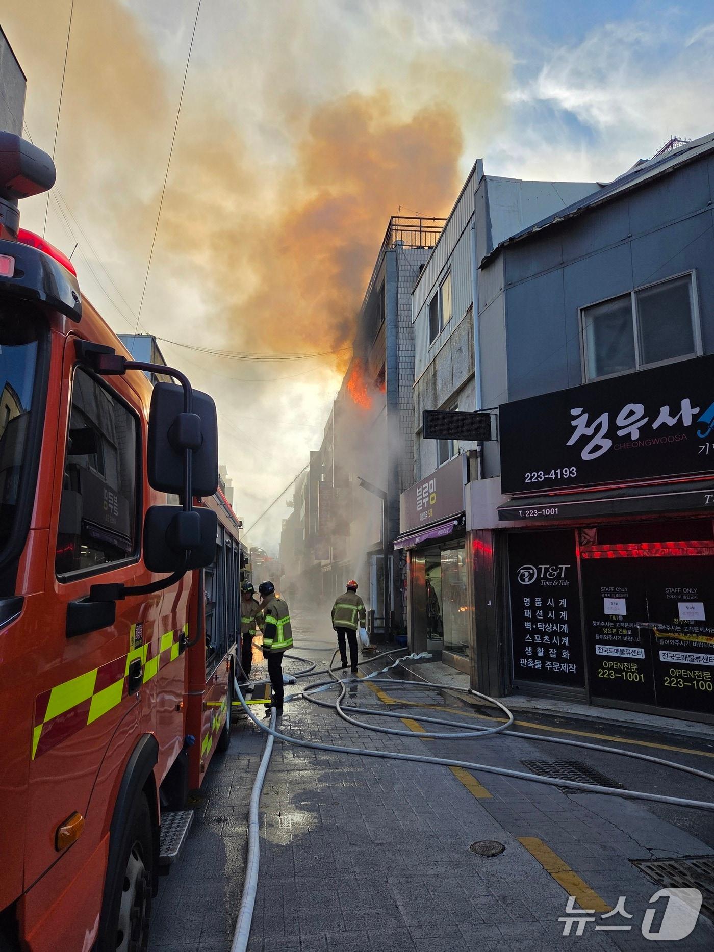 본문 이미지 - 30일 광주 동구 충장로 한 건물에 불이 나 소방당국이 진화 작업을 벌이고 있다.