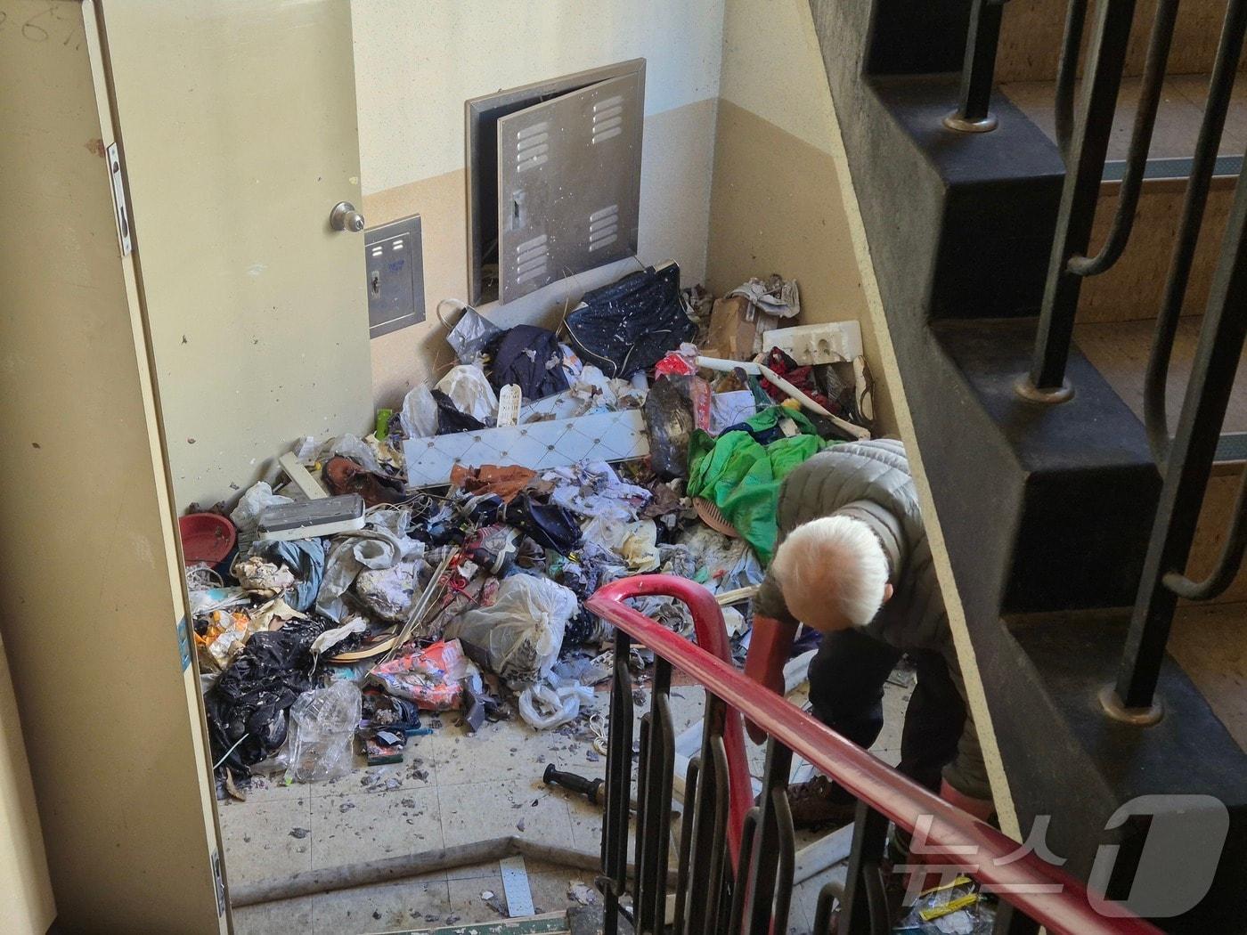 본문 이미지 - 30일 울산 남구의 한 아파트 경비원이 불에 탄 쓰레기를 치우고 있다. 지난 28일 오후 6시 56분께 이 아파트에서 불이 나 저장 강박 증세를 보인 70대 주민이 숨졌다. ⓒ News1 박정현 기자