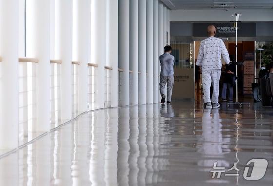 본문 이미지 - 한 환자가 서울에 있는 상급종합병원 복도를 걸어가고 있다./뉴스1 구윤성 기자