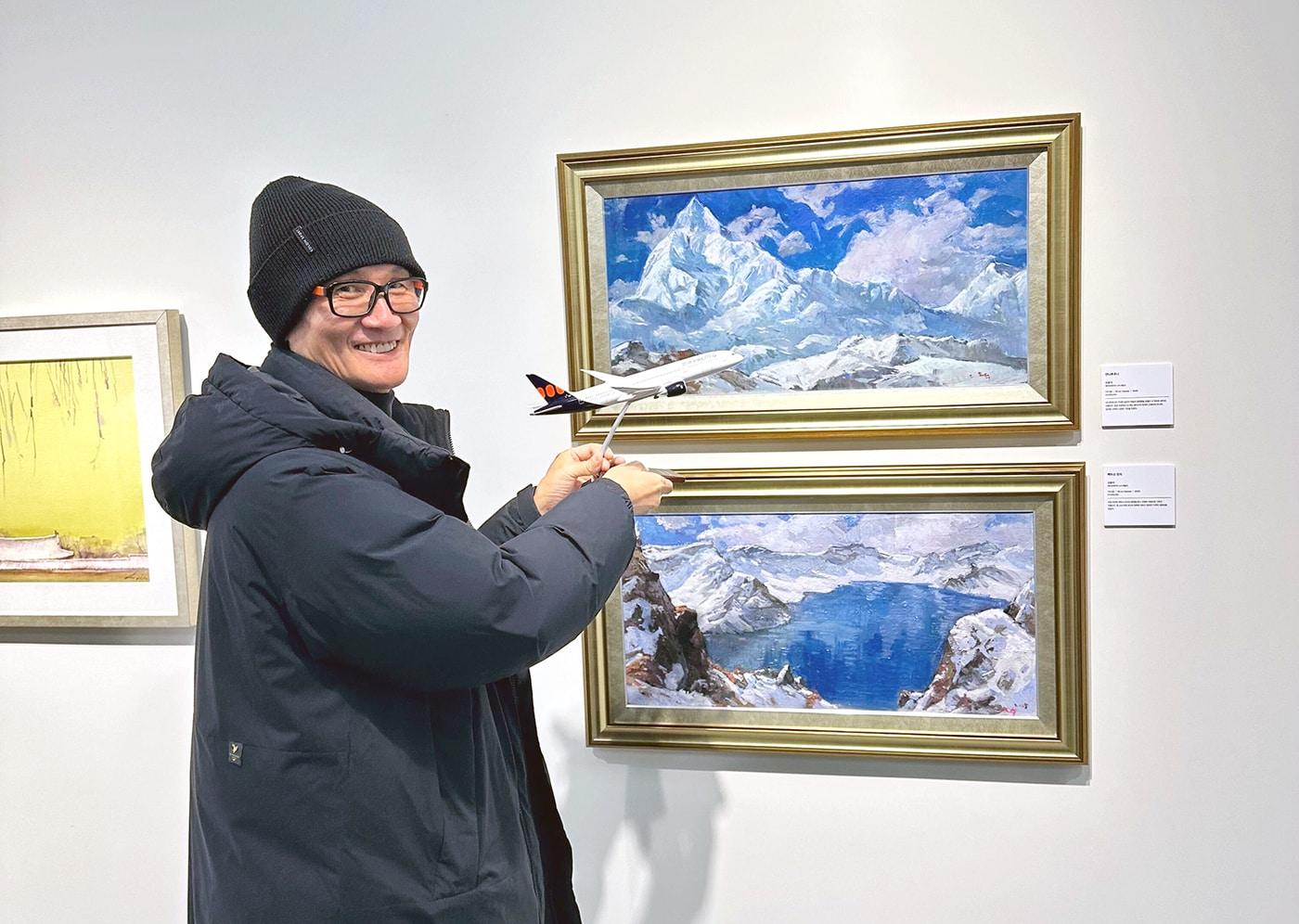 에어프레미아에 고용된 청각장애 예술인 오효석 작가가 30일 경기 과천 소재 장애예술인 전문 전시관 '갤러리 바다'에서 자신이 그린 작품과 함께 기념 사진을 촬영한 모습(에어프레미아 제공). 2025.12.30.