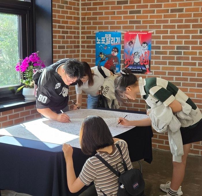 본문 이미지 - 전시 방명록을 작성하고 있는 모습 / 사진=개항로프로젝트 제공