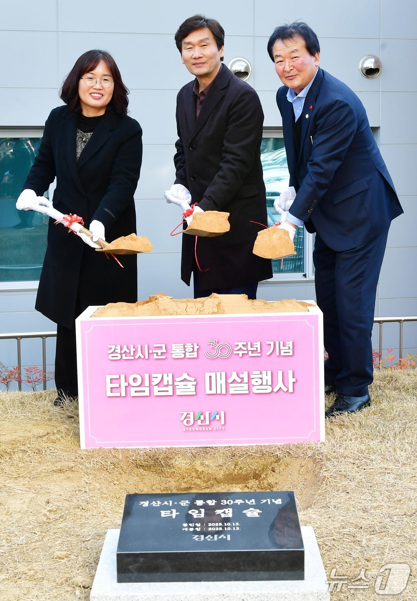 본문 이미지 - 조현일 경산시장(가운데)이 31일 시청 마당에서 시군통합 30주년 기념 타임캡슐을 매설하고 있다. (경산시 제공. 재판매 및 DB금지)/뉴스1