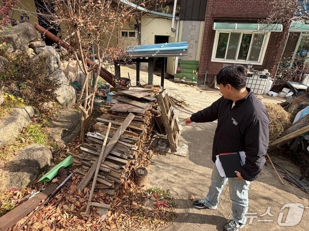 본문 이미지 - 경북 포항시가 소나무재선충병 확산 차단을 위해 소나무류 이동 특별단속에 나선 가운데  단속 공무원이 농가에 쌓인 땔감을 살펴보고 있다. &#40;포항시제공, 재판매 및 DB금지&#41; 2025.12.4/뉴스1