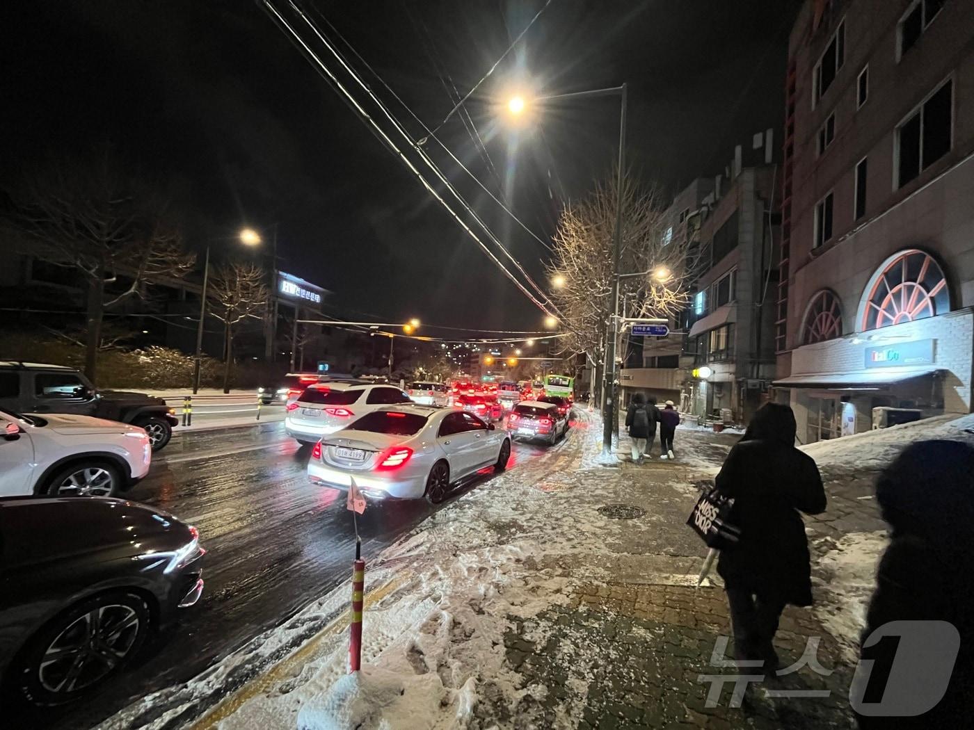 본문 이미지 - 폭설이 내린 4일 오후 서울 종로구 자하문로에서 차량들이 눈길에 큰 정체를 빚자 시민들이 버스에서 내려 걸어가고 있다.2025.12.4/뉴스1 ⓒ News1 황기선 기자