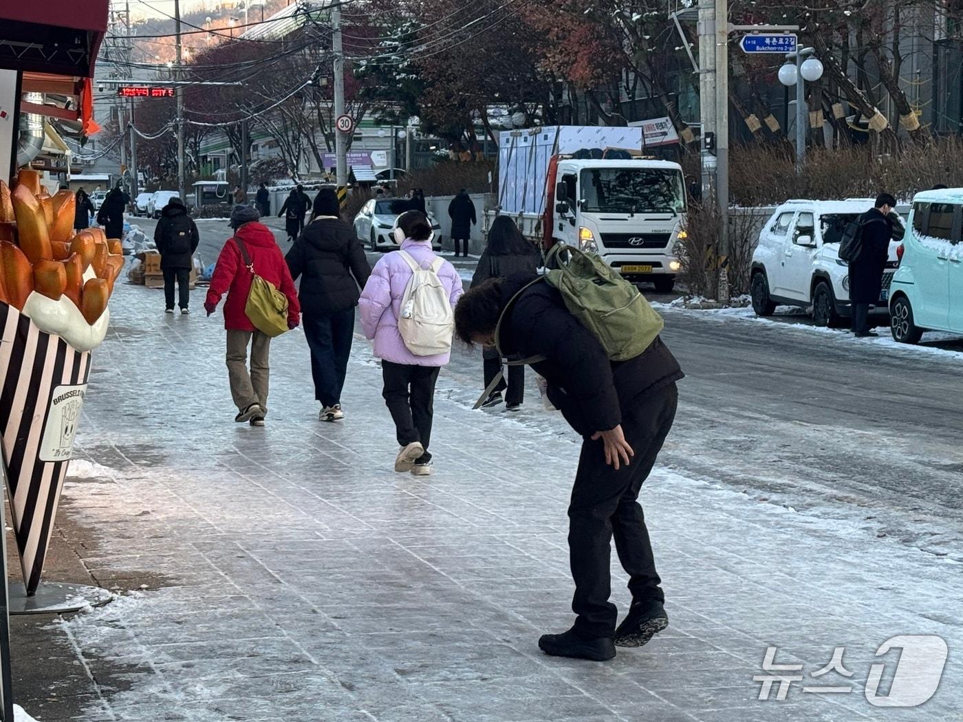 본문 이미지 - 전날&#40;4일&#41; 내린 폭설로 인해 5일 인도가 얼면서 서울 종로구 안국역 인근을 지나가는 시민들이 조심하며 걷고 있다. 2025.12.5/뉴스1 ⓒ News1 권준언 기자