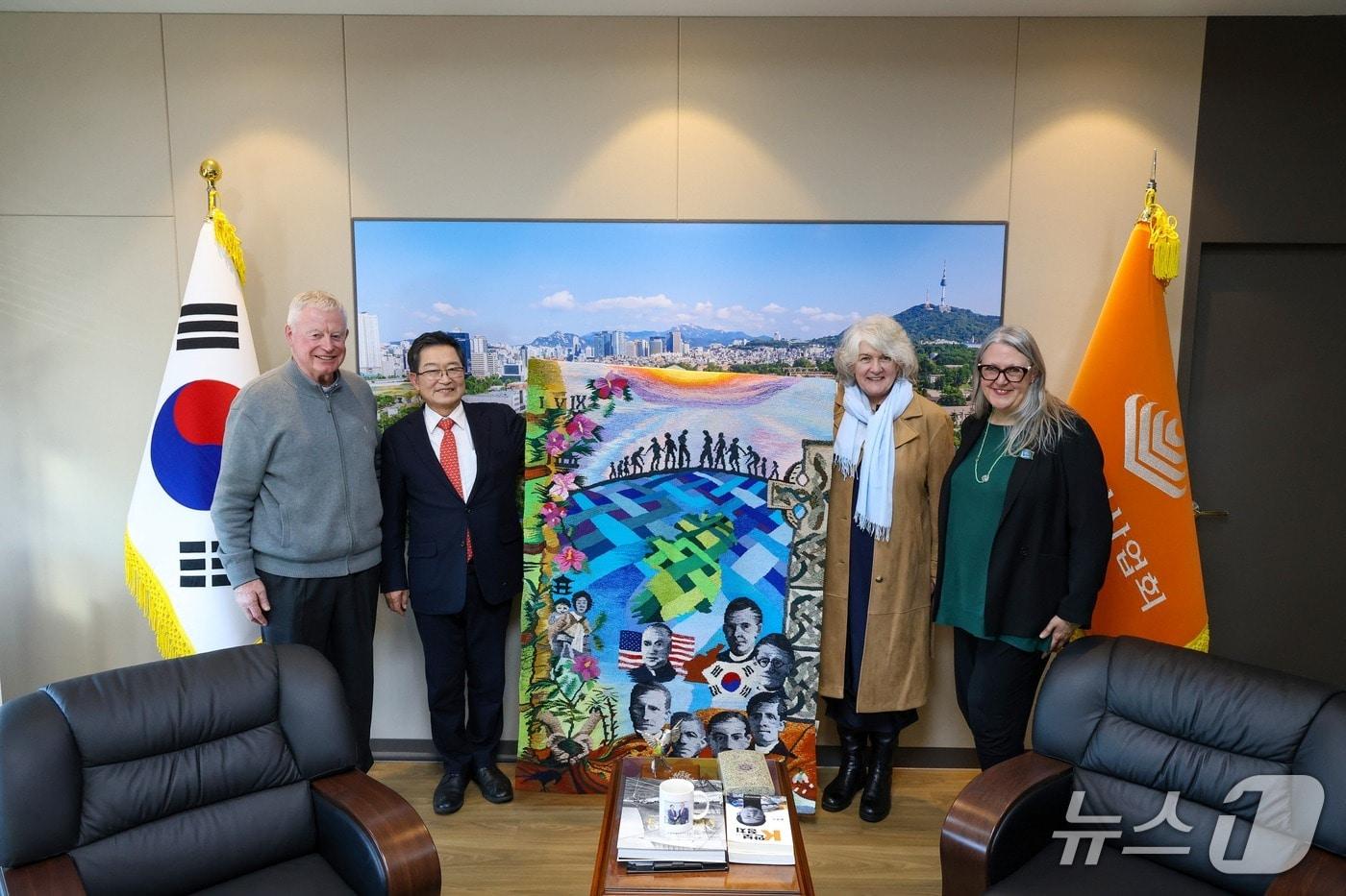 본문 이미지 - 5일 서울 용산구 전쟁기념관에서 백승주 전쟁기념사업회장과 오기백 다니엘 신부, 미쉘 윈트롭 주한아일랜드대사, 작품을 기증한 재클린 도위씨가 작품을 들고 기념촬영하고 있다. (전쟁기념사업회 제공)