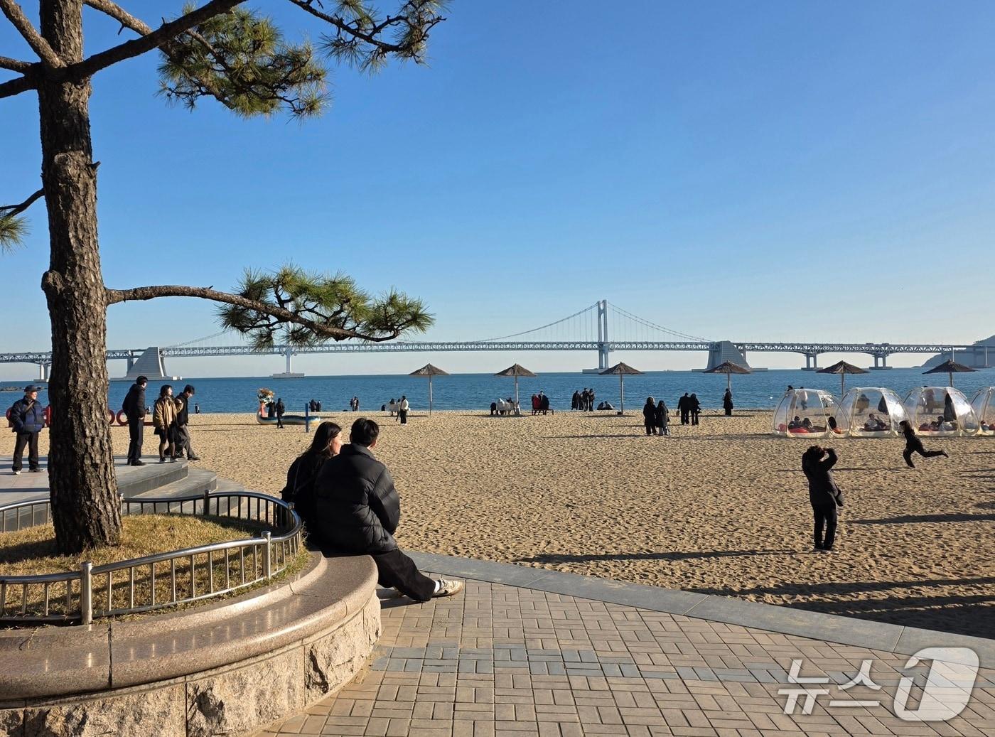 본문 이미지 - 6일 오후 부산 광안리해수욕장 인근에 시민들이 앉아있다.2025.12.6/뉴스1 ⓒ News1 장광일 기자