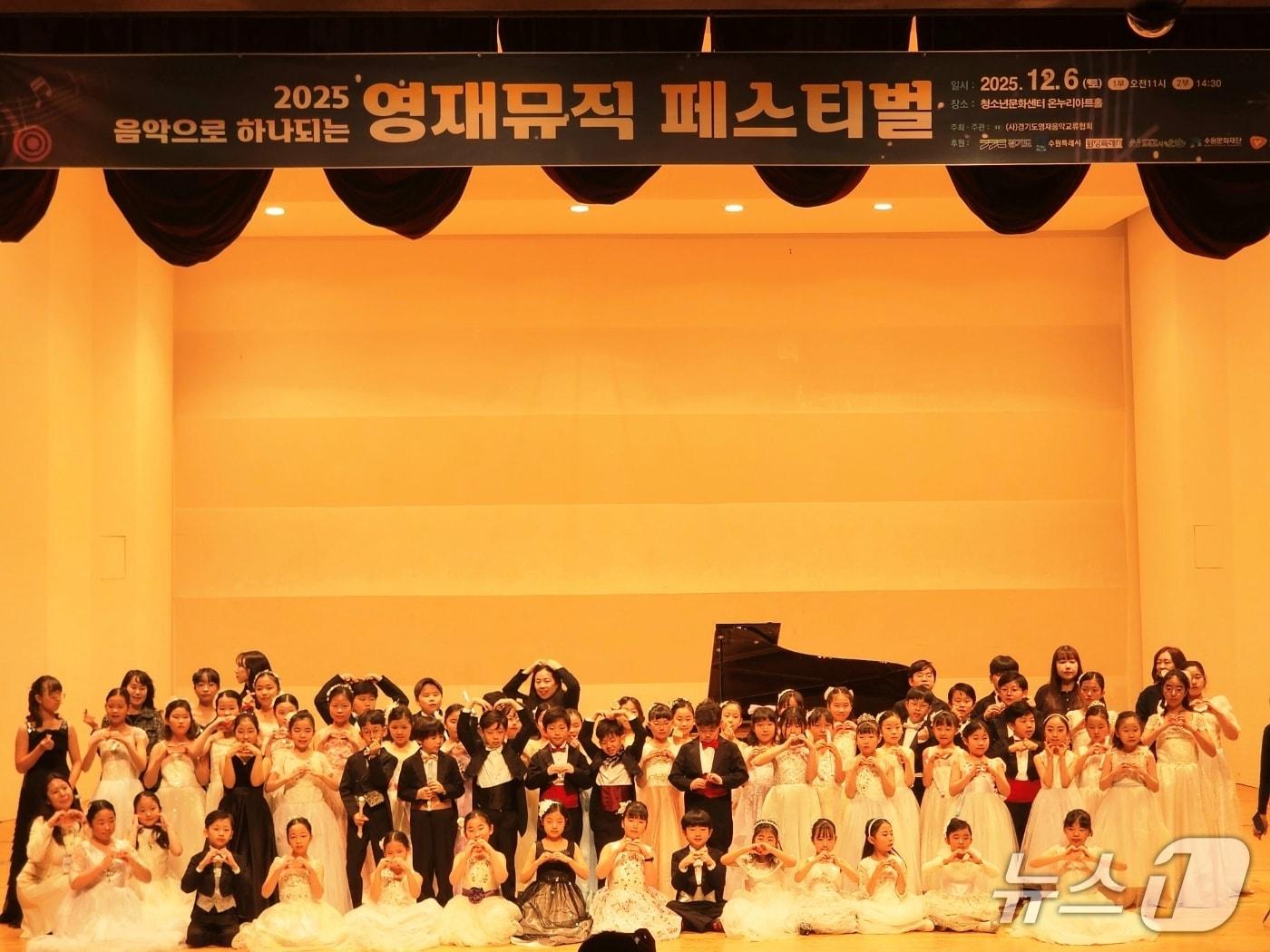 본문 이미지 - 2025년 음악으로 하나되는 영재뮤직 페스티벌에 참가한 학생들이 무대에서 기념촬영을 하고 있다.&#40;경기도영재음악교류협회 제공&#41; 