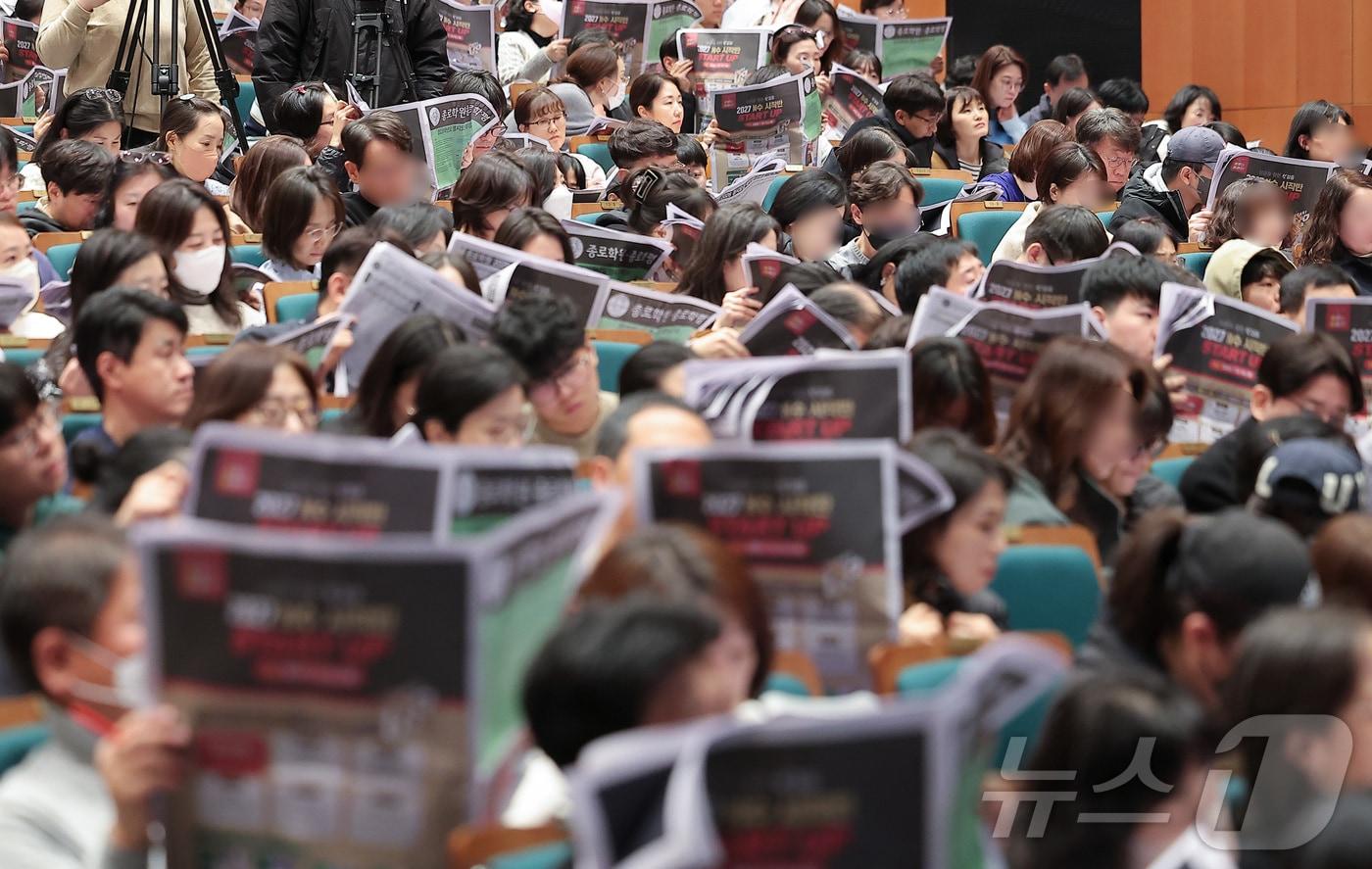 본문 이미지 - 7일 서울 종로구 성균관대학교 600주년 기념관 천년홀에서 열린 종로학원 2026 정시 합격 가능선 예측 및 지원전략 설명회를 찾은 학부모들이 입시 자료를 보며 설명을 듣고 있다. 2025.12.7/뉴스1 ⓒ News1 김성진 기자