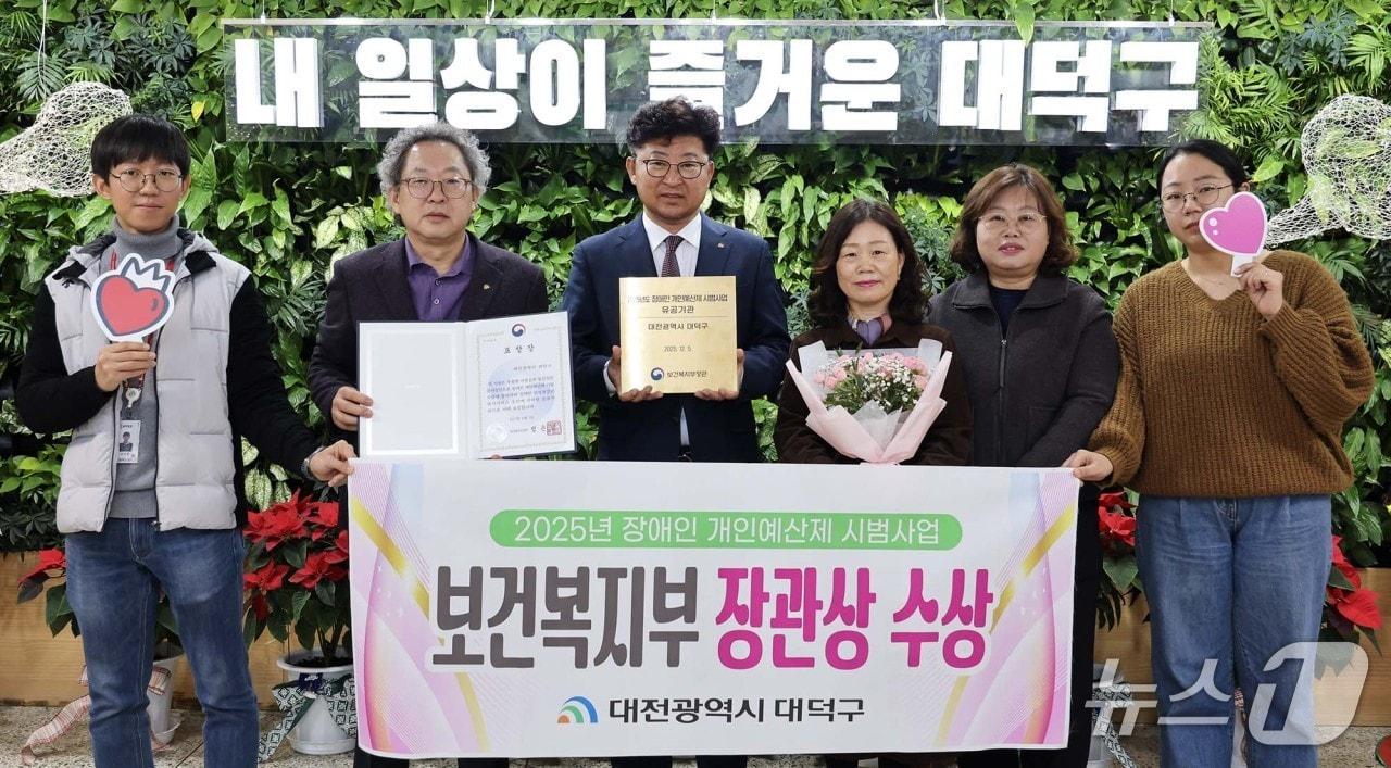 본문 이미지 - 최충규 대덕구청장&#40;왼쪽 세 번째&#41;과 직원들이 ‘2025년 장애인 개인예산제 시범사업’에서 보건복지부 장관 표창을 받은 후 기념 촬영을 하고 있다.&#40;대덕구 제공. 재판매 및 DB금지&#41;/뉴스1