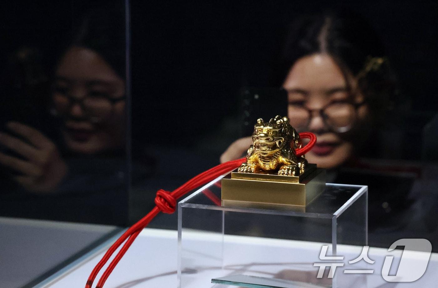 8일 서울 중구 덕수궁 돈덕전에서 열린 국가유산청과 데브시스터즈 공동주최 제2회 국가유산의 날 기념 특별전 &#39;쿠키런: 사라진 국가유산을 찾아서&#39; 공개 행사에서 관계자가 복원된 &#39;대한국새&#39;를 둘러보고 있다. 오는 9일 부터 내년 3월 1일 까지 열리는 이번 전시는 자주적 근대국가를 만들고자 했던 대한제귝의 미완의 꿈과 쿠키런의 핵심 가치인 용기를 결합하여 국가유산의 가치를 조망하고 시대를 초월한 희망의 메시지를 전하고자 마련됐다 2025.12.8/뉴스1 ⓒ News1 김명섭 기자