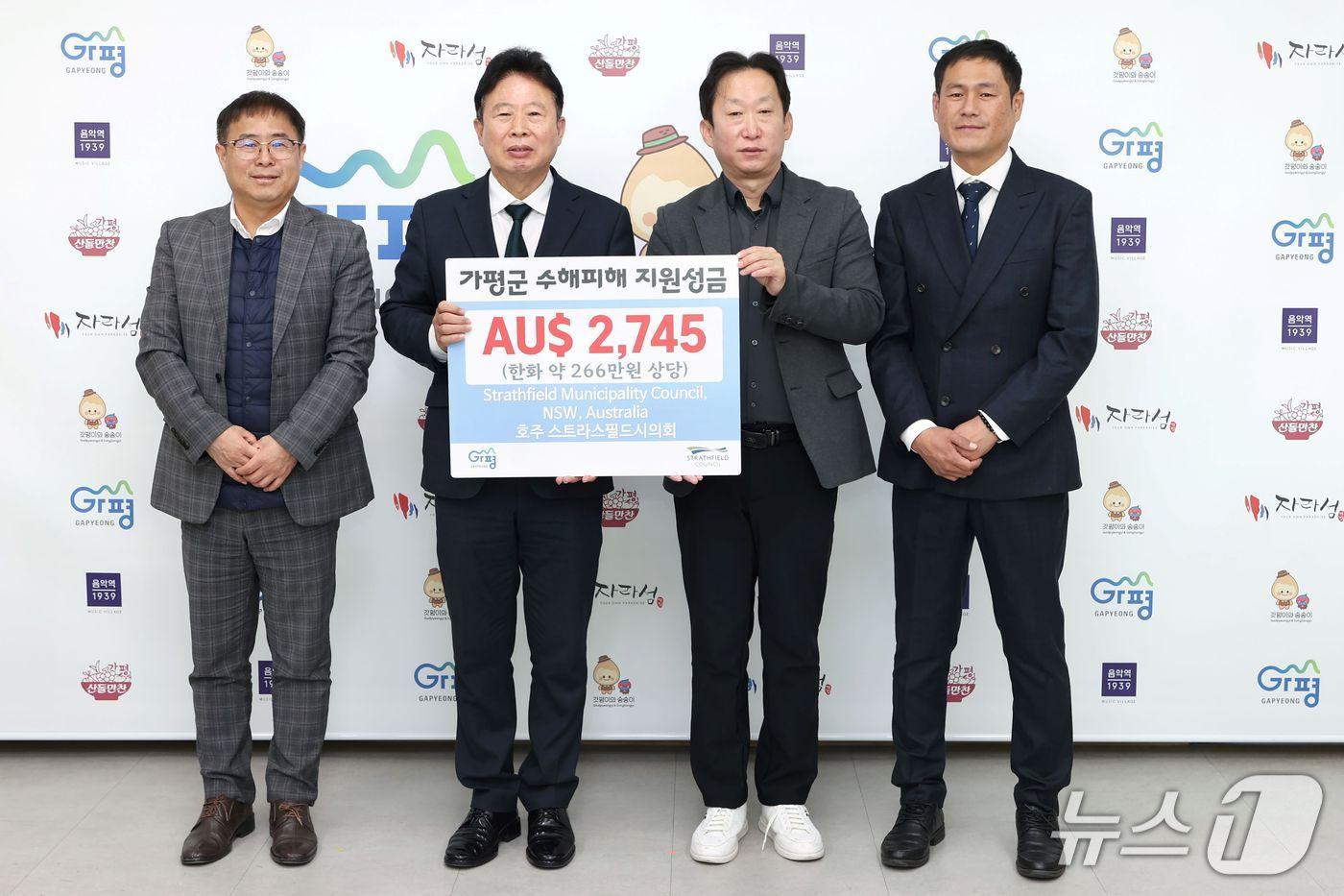  호주 뉴사우스웨일스주 스트라스필드시가 경기 가평군에 전달한 수해 성금. 서태원 군수가 기념사진을 찍고 있다.&#40;가평군 제공. 재판매 및 DB 금지&#41;/뉴스1 