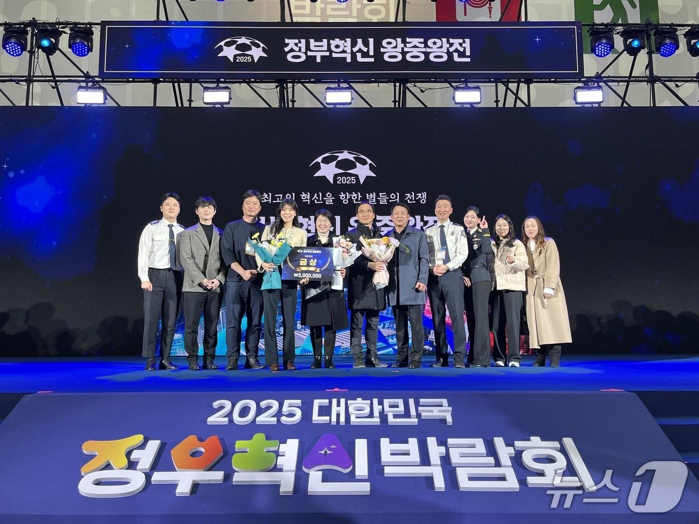 본문 이미지 - 소방청 관계자들이 2025년 정부혁신 왕중왕전에서 대통령상 수상 후 기념사진을 촬영하고 있다