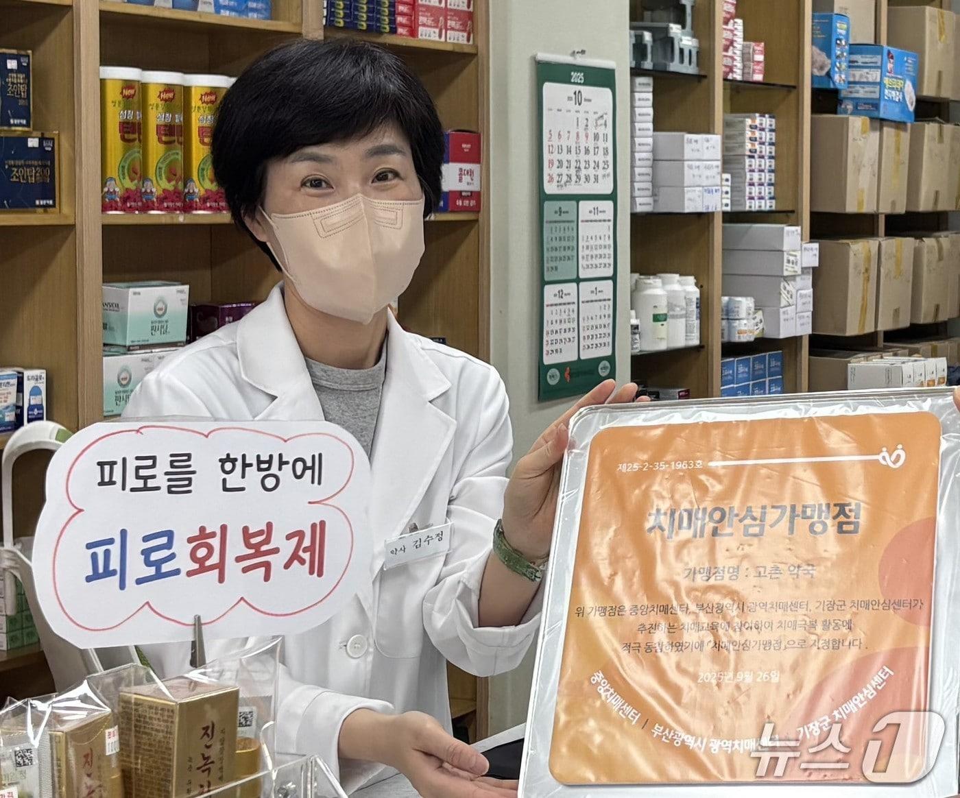 본문 이미지 - 기장군 철마면 고촌약국 김수정 대표가 기장군 치매안심가맹점 지정 현판을 전달 받고 있다.&#40;기장군 제공. 재판매 및 DB금지&#41;