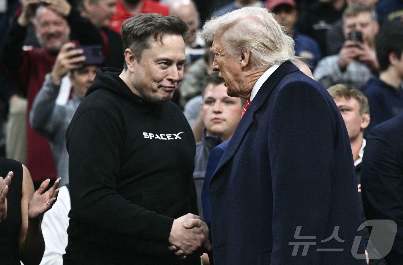 도널드 트럼프 미국 대통령과 일론 머스크 테슬라 최고경영자&#40;CEO&#41;가 지난 3월 펜실베이니아주 필라델피아 웰스파고 센터에서 열린 스포츠 행사에서 만나 악수하고 있다. ⓒ AFP=뉴스1 ⓒ News1 류정민 특파원