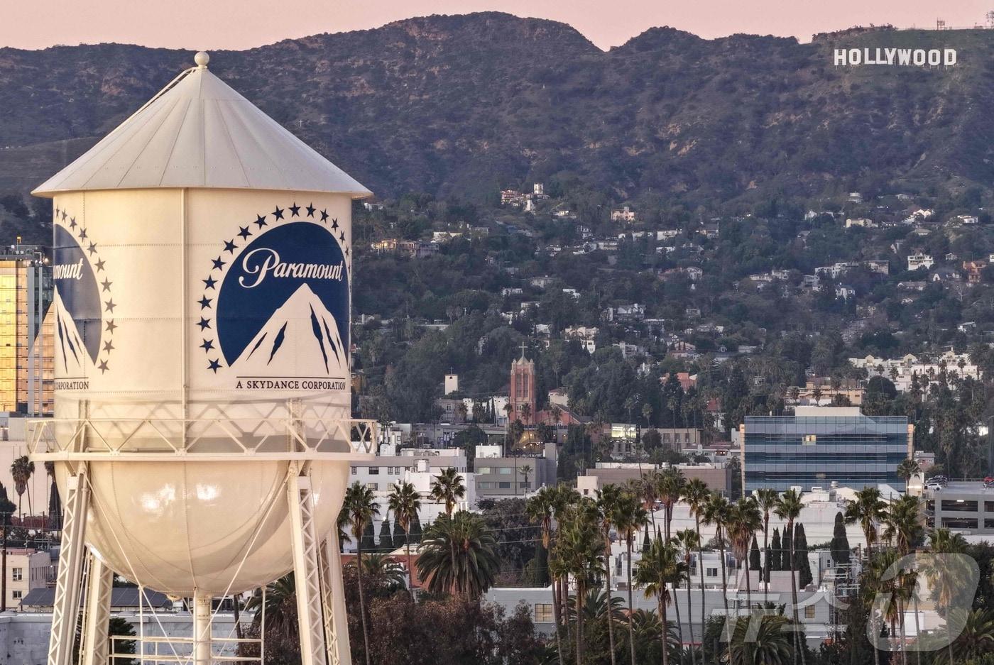 8일&#40;현지시간0 캘리포니아주 로스앤젤레스에서 할리우드 간판을 배경으로 촬영된 파라마운트 스튜디오 내 워터 타워가 보인다. 2025.12.8 ⓒ AFP=뉴스1