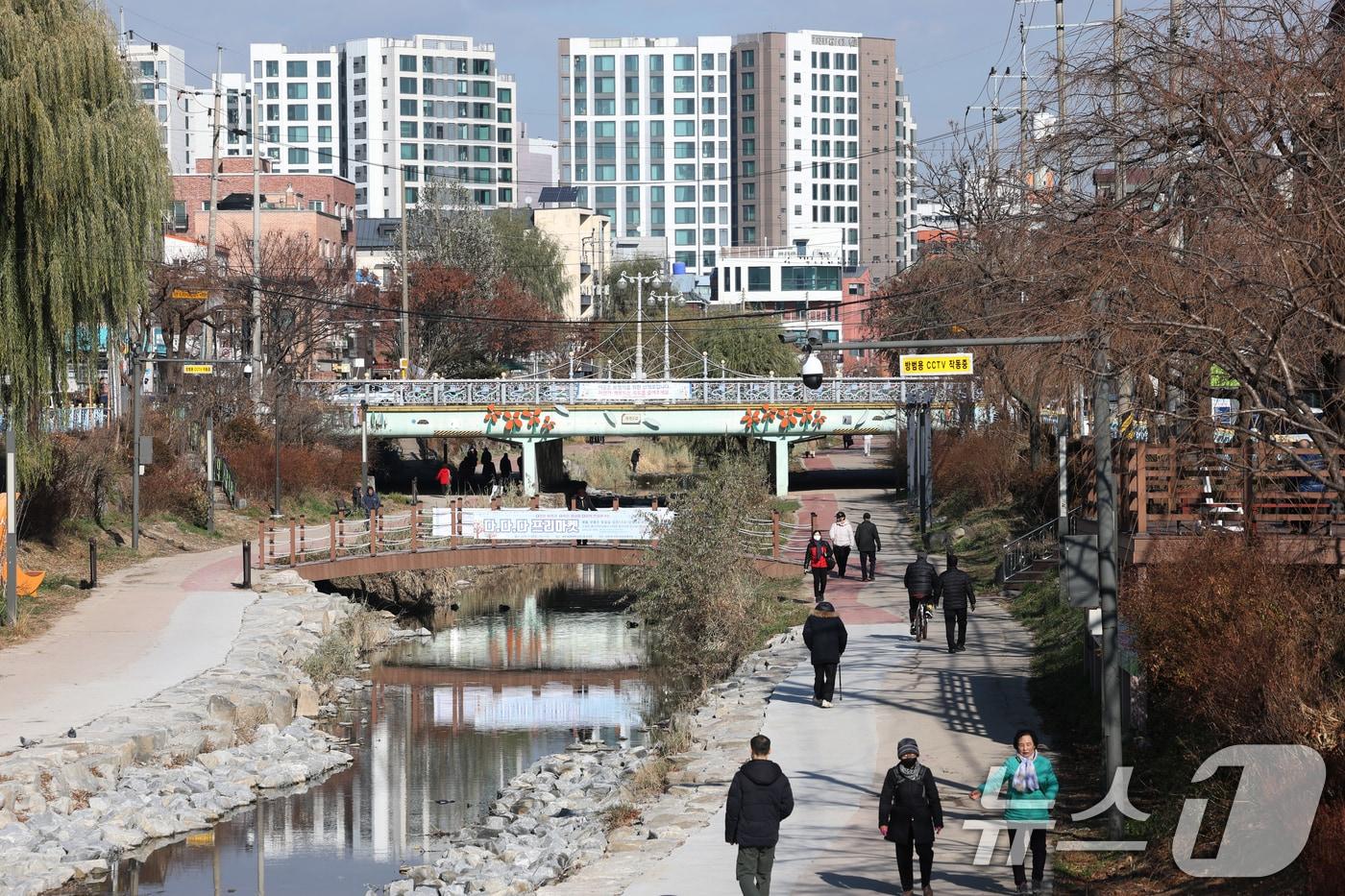 포근한 겨울 날씨를 보인 9일 경기 수원시 권선구 세류천에서 시민들이 산책을 즐기고 있다. 2025.12.9/뉴스1 ⓒ News1 김영운 기자