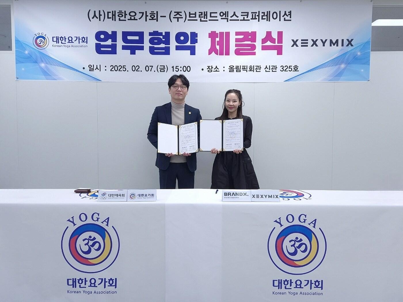 본문 이미지 - 이수연 브랜드엑스코퍼레이션 회장(오른쪽)과 강승진 대한요가회 회장이 협약서에 서명한 후 기념촬영을 진행하고 있다.(브랜드엑스코퍼레이션제공)