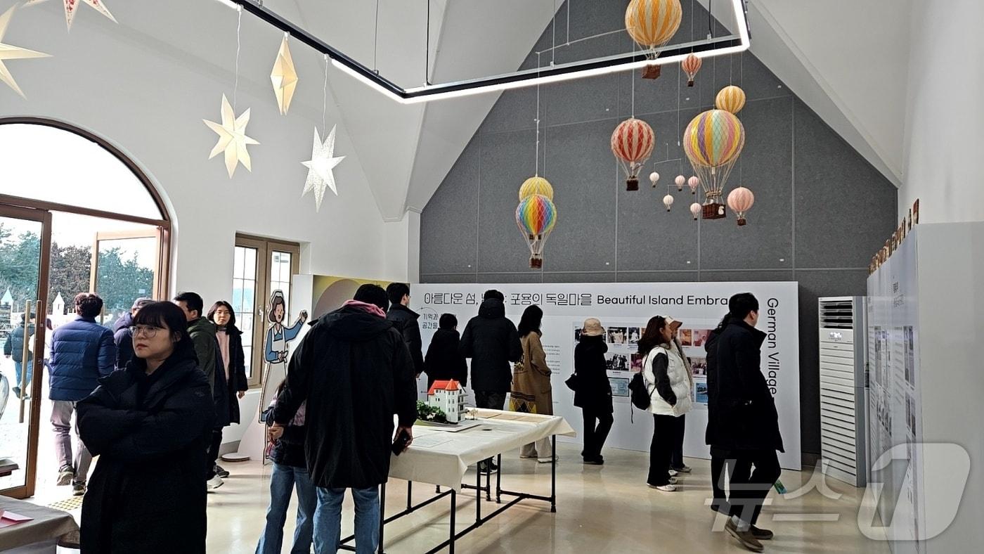 본문 이미지 - 남해독일마을 광장 여행라운지에 마련한 '포용의 독일마을' 특별 전시회.(남해관광문화재단 제공)
