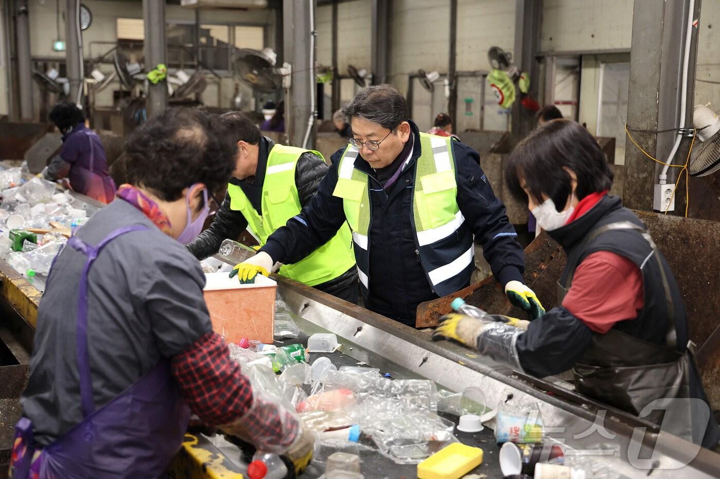 본문 이미지 - 홍태용 김해시장(가운데)이 10일 김해시 재활용품선별장에서 재활용품 선별 작업을 하고 있다.(김해시 제공)