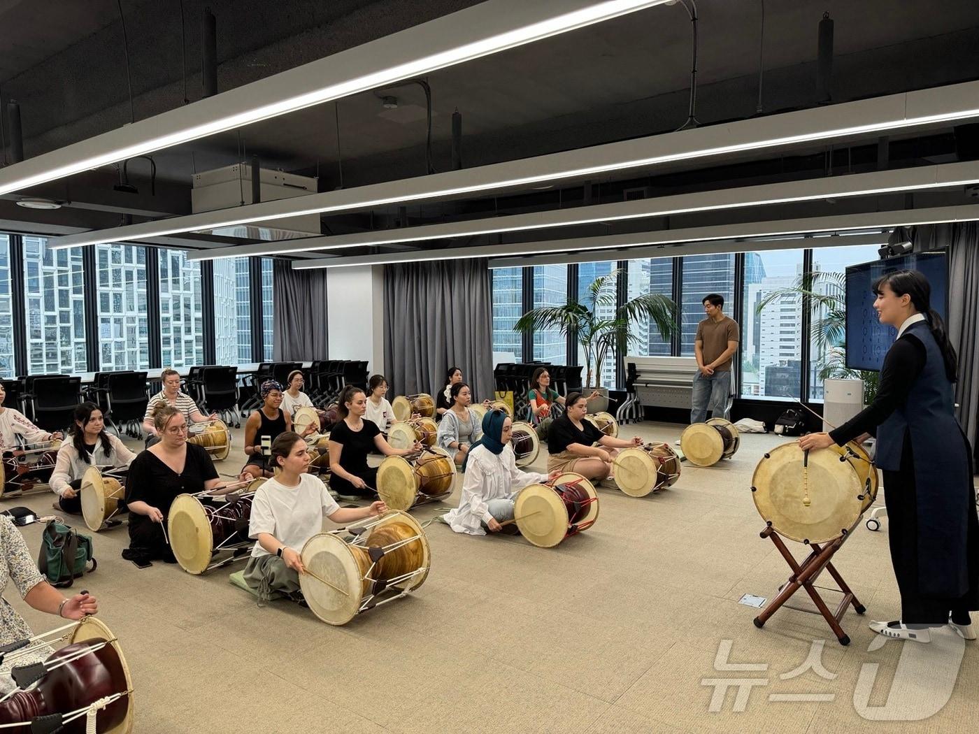 본문 이미지 - 외국인 참여자들이 장구를 직접 연주하는 모습(서울관광재단 제공)