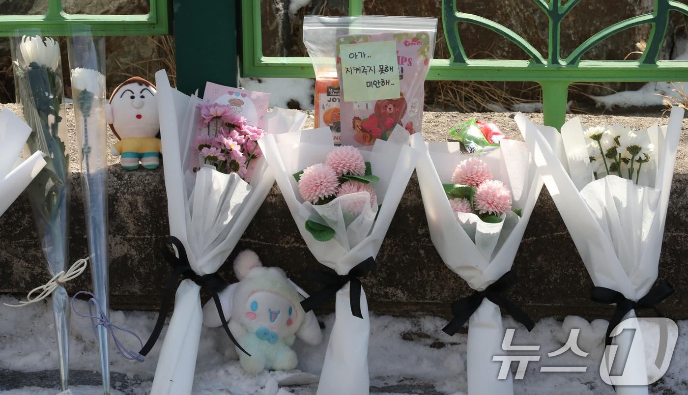 본문 이미지 - 지난 10일 대전 서구 한 초등학교에서 1학년 A양이 교사에 의해 흉기에 찔려 사망하는 사고가 발생했다. 11일 범행이 발생한 학교입구에 A양을 추모하는 국화꽃과 메모가 놓여 있다. 2025.2.11/뉴스1 ⓒ News1 김기태 기자