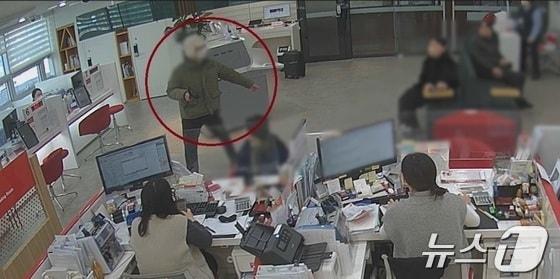 본문 이미지 - 10일 오전 부산 기장군 일광읍에 있는 한 은행에서 강도가 고객과 직원을 위협하고 있다.(은행 CCTV 영상갈무리)