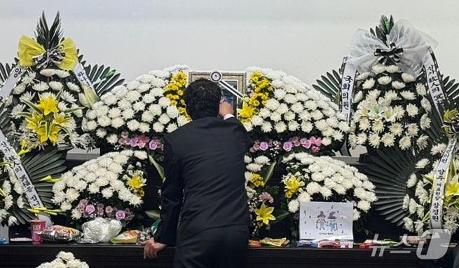 본문 이미지 - 12일 대전 서구 한 초등학교에서 40대 교사에게 살해된 김하늘양의 아버지가 건양대병원 장례식장에 마련된 빈소에서 하늘양의 영정사진을 어루만지고 있다. 2025.2.12/뉴스1 ⓒ News1 양상인 기자