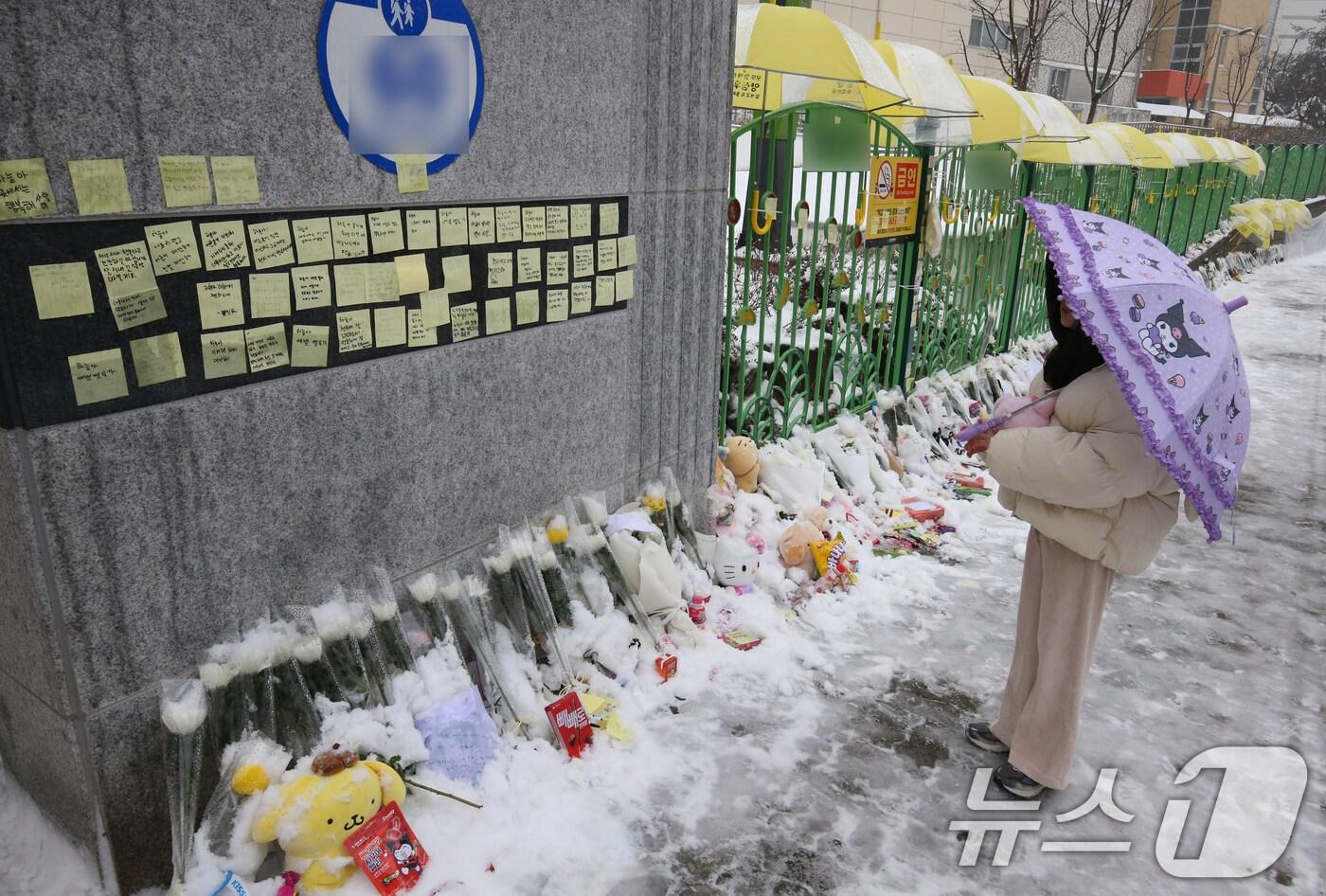 12일 대전 초등학생 피살사건이 발생한 대전 서구의 한 초등학교 정문에 추모객들이 놓고 간 국화과 편지 위에 우산이 설치돼 있다. 2025.2.12/뉴스1 ⓒ News1 양상인 기자
