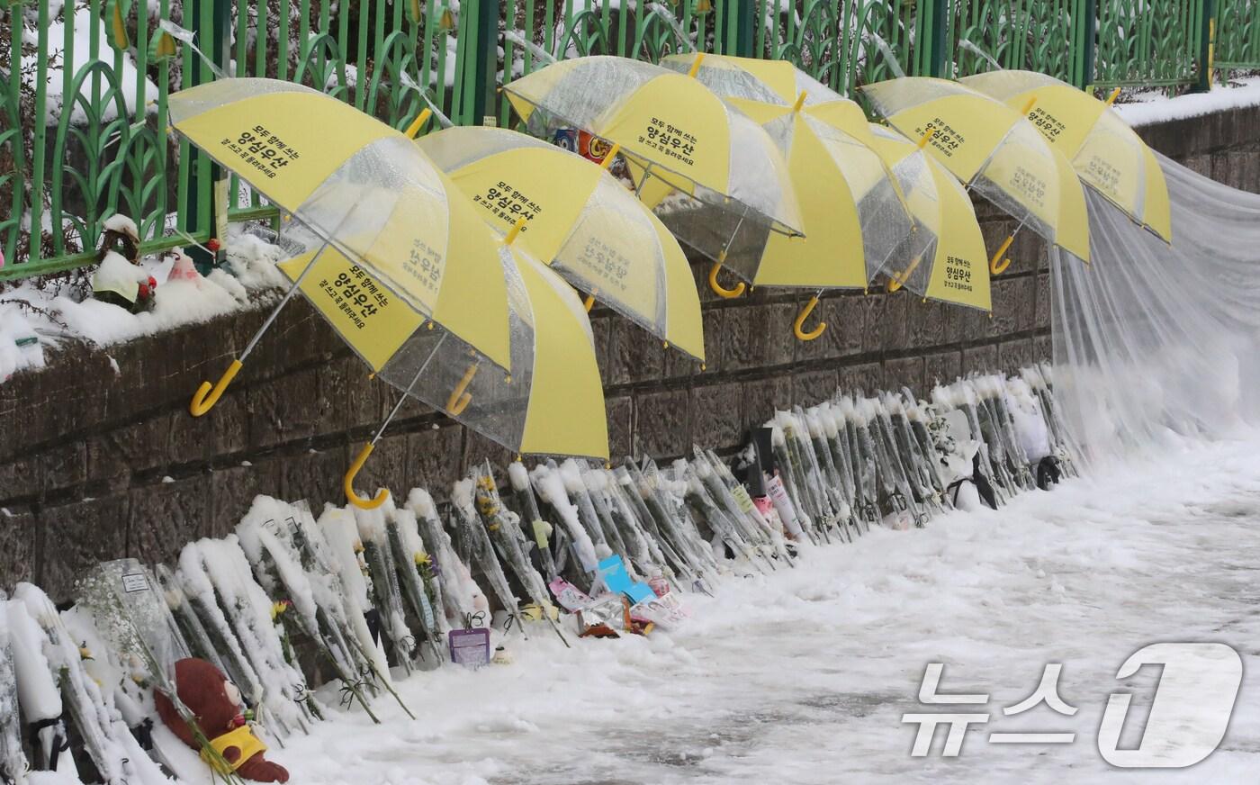 12일 대전 초등학생 피살사건이 발생한 대전 서구의 한 초등학교 정문에 추모객들이 놓고 간 국화과 편지 위에 우산이 설치돼 있다. 2025.2.12/뉴스1 ⓒ News1 양상인 기자