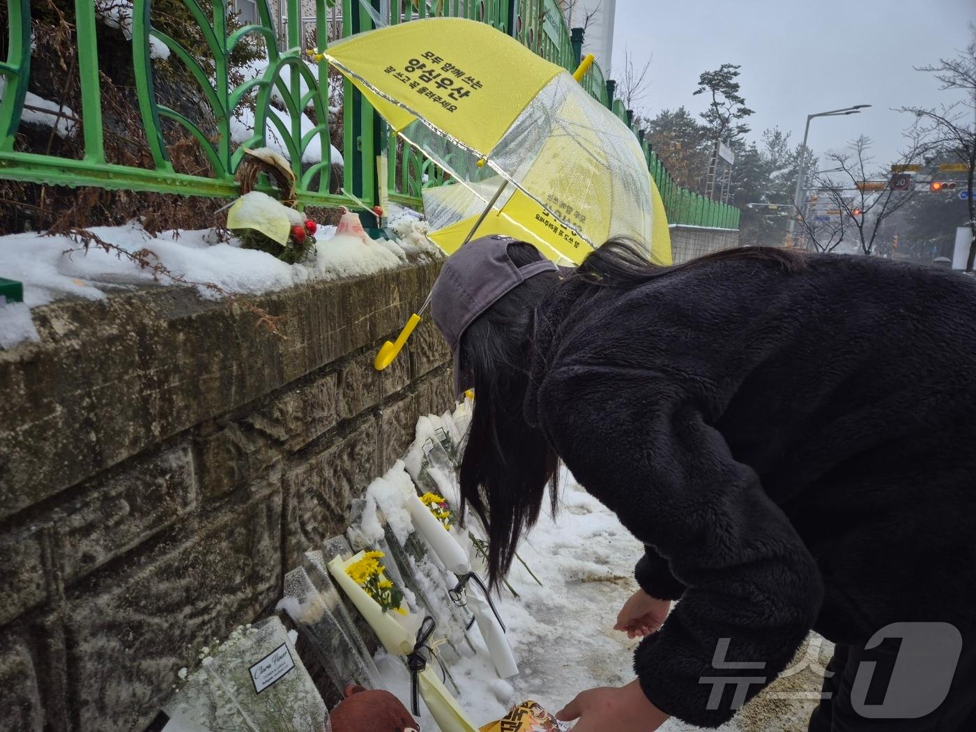 본문 이미지 -  대전 초등학교 살해 사건으로 고인이 된 김하늘 양을 추모하기 위해 합동 분향소를 방문한 시민이 꽃다발을 놓고 있다. 2025.2.12/뉴스1 ⓒ News1 최형욱 기자