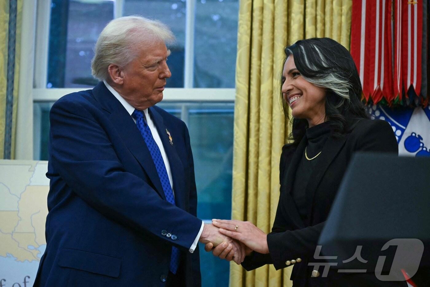 도널드 트럼프 미국 대통령이 지난 2월 11일&#40;현지시간&#41; 워싱턴 백악관에서 열린 털시 개버드 국가정보국&#40;DNI&#41; 국장의 취임식서 악수를 하고 있다. 2025.02.13 ⓒ AFP=뉴스1 ⓒ News1