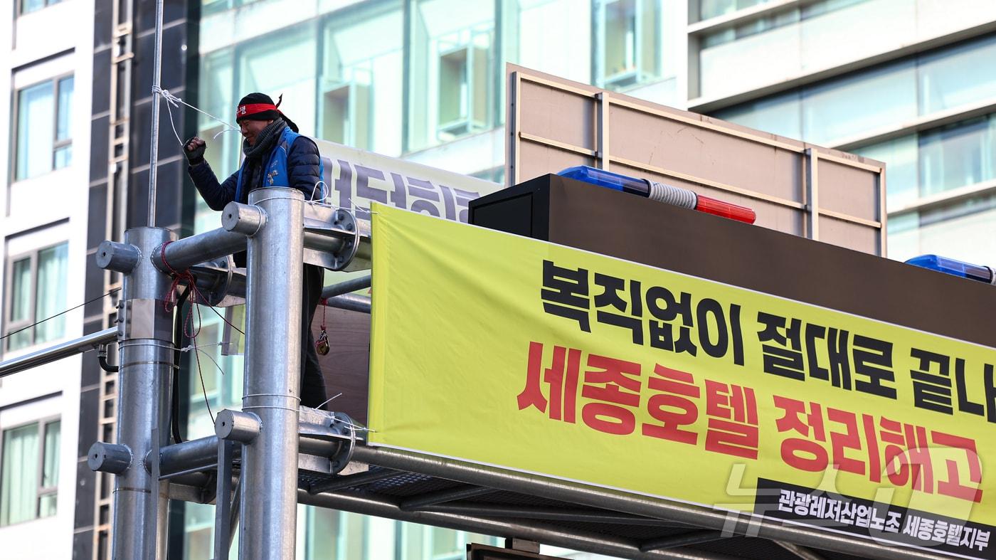 본문 이미지 - 세종호텔에서 해고된 고진수 관광레저산업노조 세종호텔 지부장이 지난해 2월 13일 서울 중구 세종호텔 앞 지하차도진입차단시설에 올라 복직을 요구하며 농성을 하고 있다. 2025.2.13/뉴스1 ⓒ News1 김도우 기자