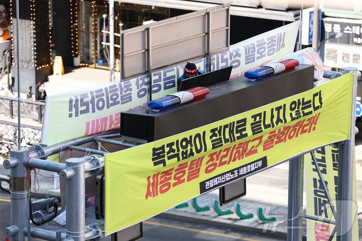 본문 이미지 - 세종호텔에서 해고된 고진수 관광레저산업노조 세종호텔 지부장이 지난해 2월 13일 서울 중구 세종호텔 앞 지하차도진입차단시설에 올라 복직을 요구하며 농성을 하고 있다.  2025.2.13/뉴스1 ⓒ News1 김도우 기자