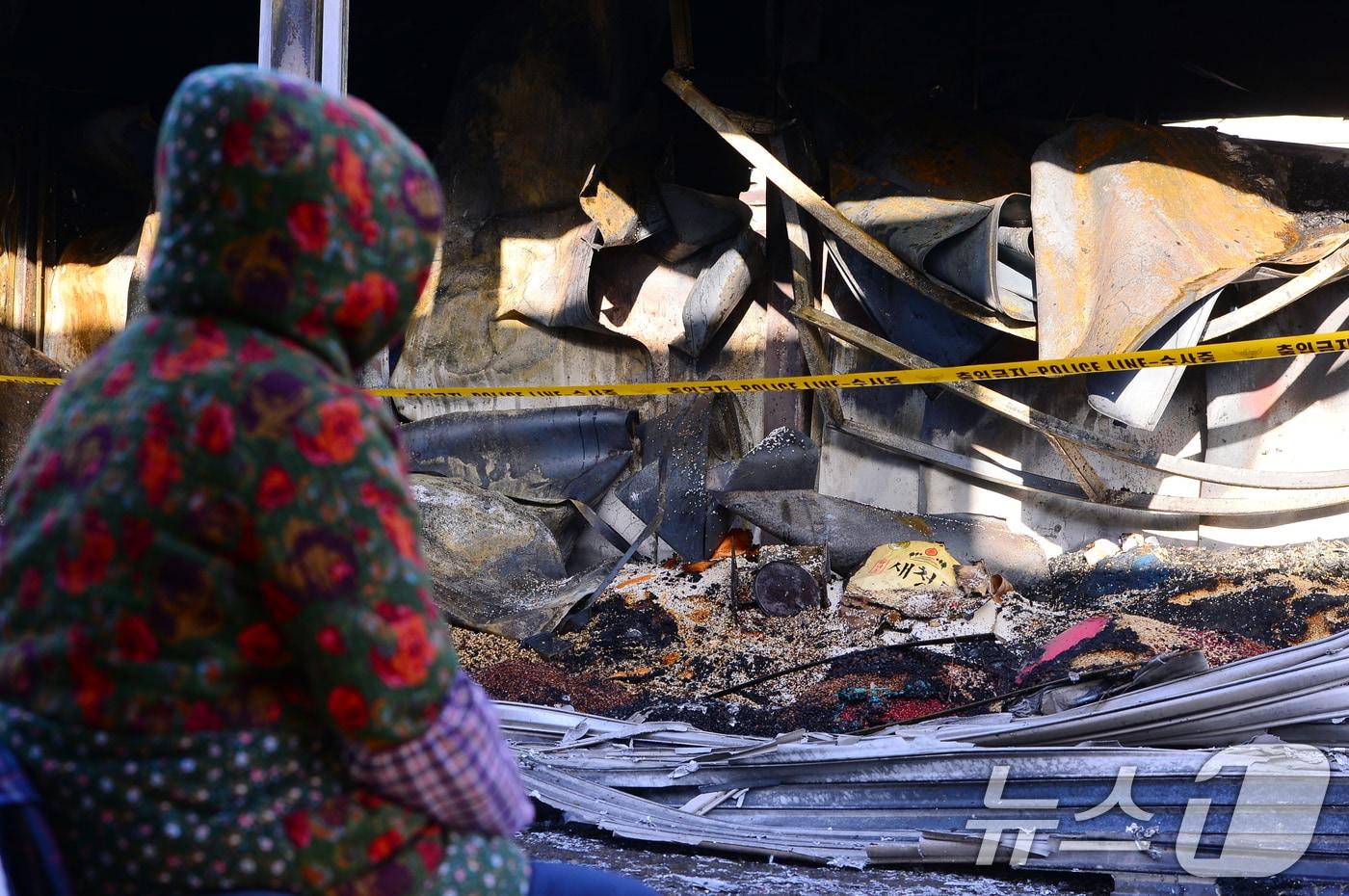 14일 오전 광주 광산구 송정5일시장 내 화재 피해를 입은 한 상인이 점포를 바라보고 있다. 2025.2.14/뉴스1 ⓒ News1 이승현 기자
