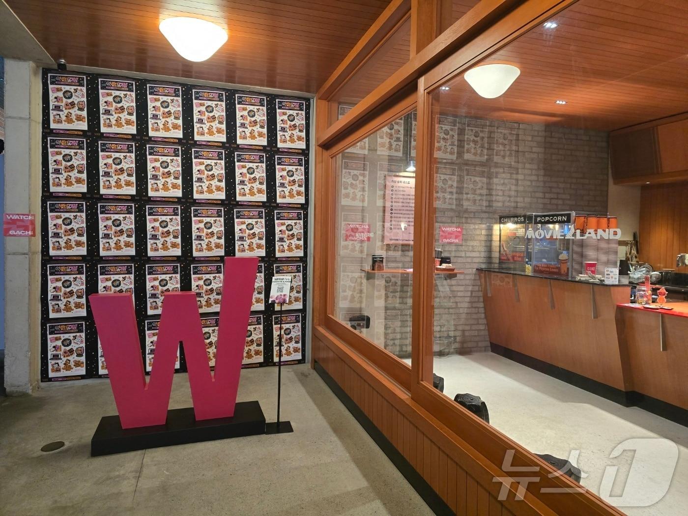 본문 이미지 - 12일 오후 7시쯤 '왓챠파티@무비랜드'에 참여하기 위해 서울 성수동 무비랜드를 찾았다. 극장 앞쪽으로 왓챠 로고와 함께 이번 테마 '발견의 기쁨'을 뜻하는 포스터가 자리하고 있다. ⓒ 뉴스1 양새롬 기자