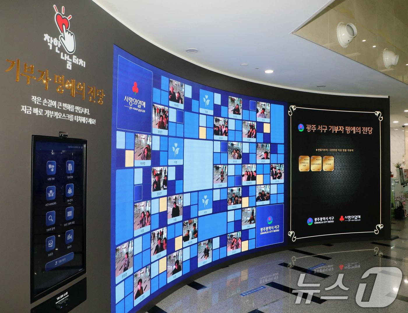본문 이미지 - 14일 광주 서구청사 1층 로비에 마련된 기부 키오스크의 모습. 키오스크 옆 명예의 전당에는 기부자들의 인증샷이 나타난다. 2025.2.14/뉴스1 ⓒ News1 이수민 기자