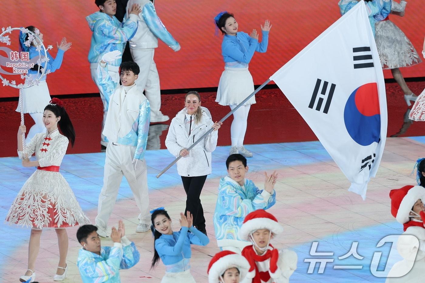 14일 중국 헤이룽장성 하얼빈 국제 컨벤션 전시 스포츠센터에서 열린 제9회 하얼빈 동계아시안게임 폐회식에서 대한민국 기수 예카테리나 압바꾸모바가 태극기를 들고 입장하고 있다. . 2025.2.14./뉴스1 ⓒ News1 이승배 기자
