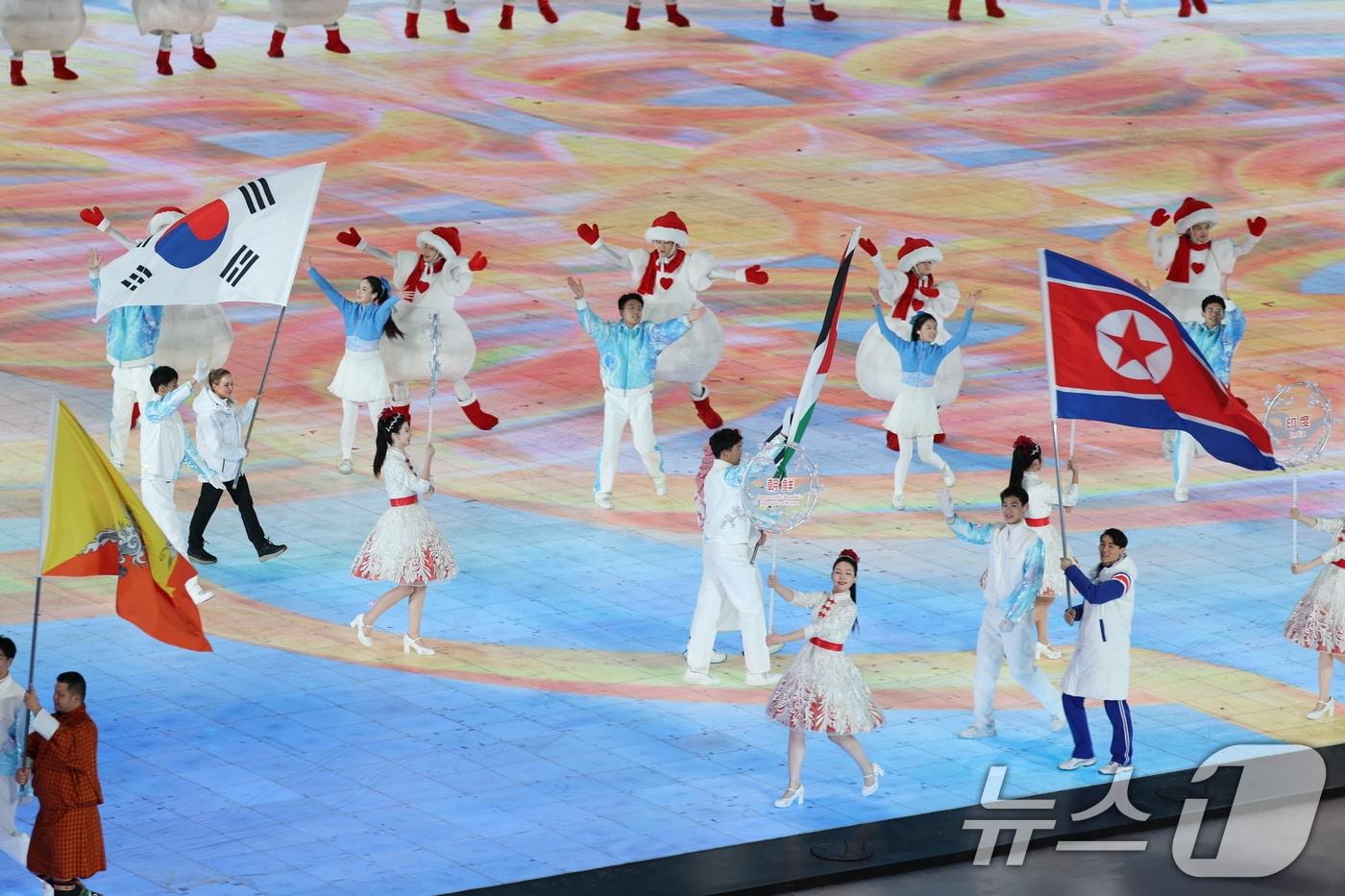 지난 2월 제9회 하얼빈 동계아시안게임 폐회식에서 대한민국 기수 예카테리나 압바꾸모바가 태극기를 들고, 북한 기수 현금철이 인공기를 들고 입장하고 있다. 2025.2.14/뉴스1 ⓒ News1 이승배 기자