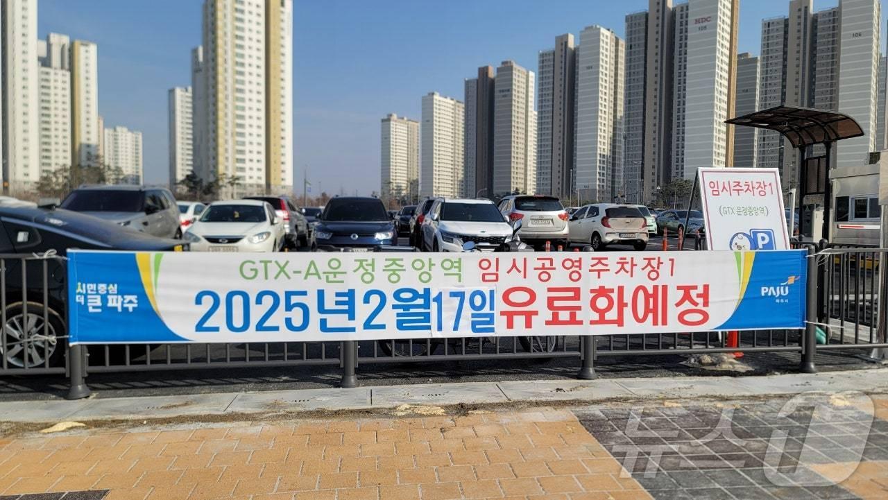 본문 이미지 - 경기 파주시 GTX 운정중앙역 임시주차장에 오는 17일부터 유료화 전환을 알리는 현수막이 걸려 있다. &#40;운정신도시연합회 제공, 재판매 및 DB 금지&#41;
