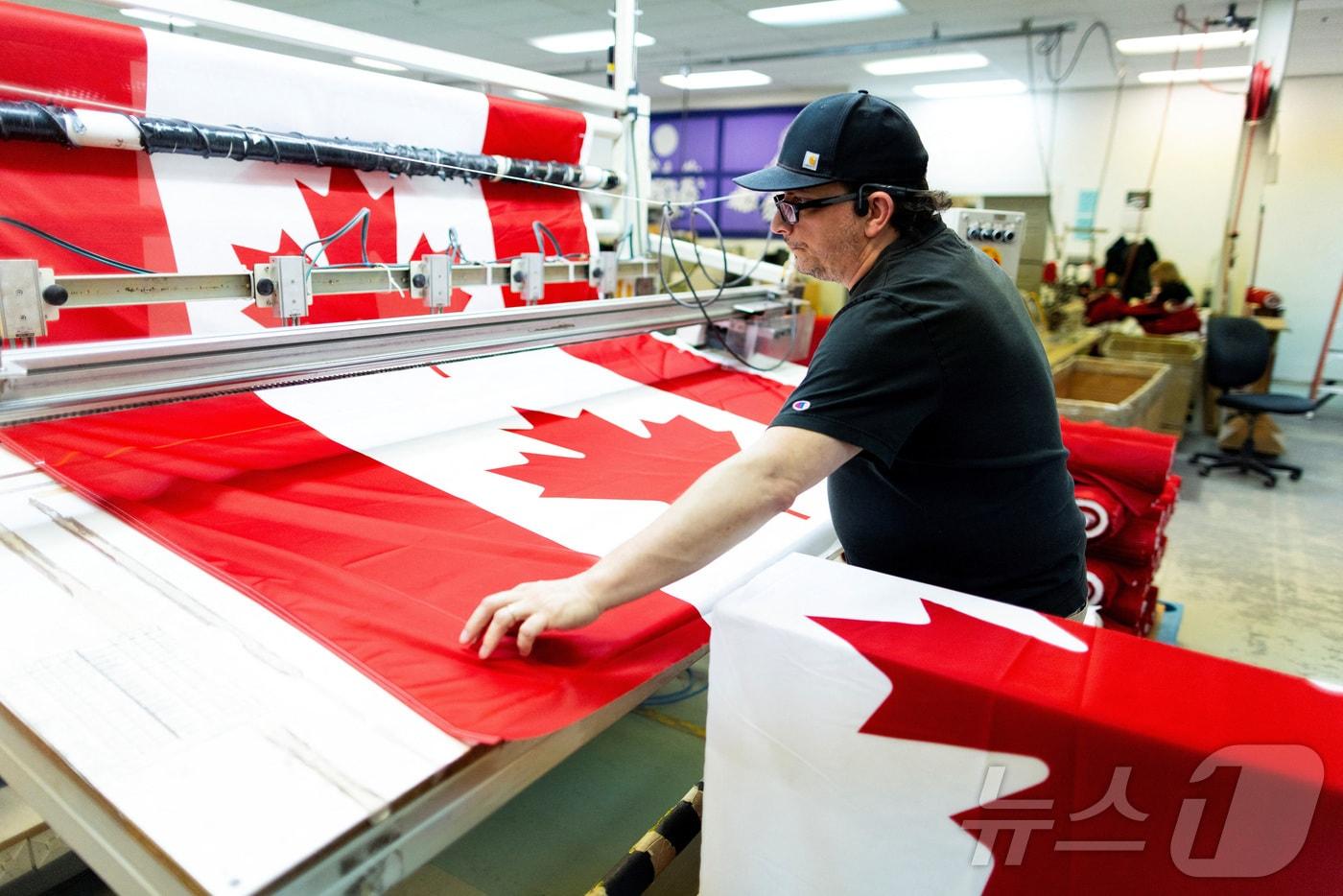 캐나다 온타리오주 배리의 한 공장에서 캐나다 국기가 생산되고 있다. 2025.2.12 ⓒ 로이터=뉴스1 ⓒ News1 강민경 기자